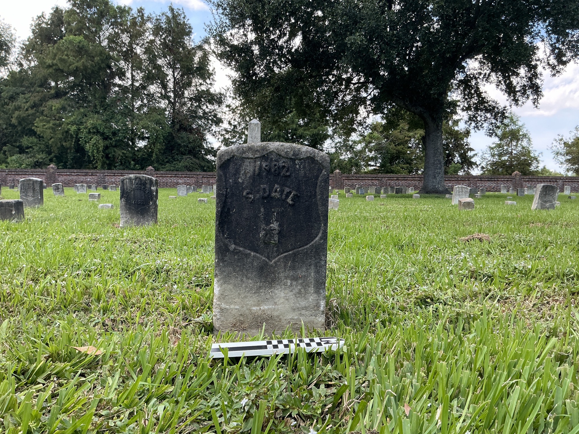Extra image of historic upright marble headstone with recessed shield face.