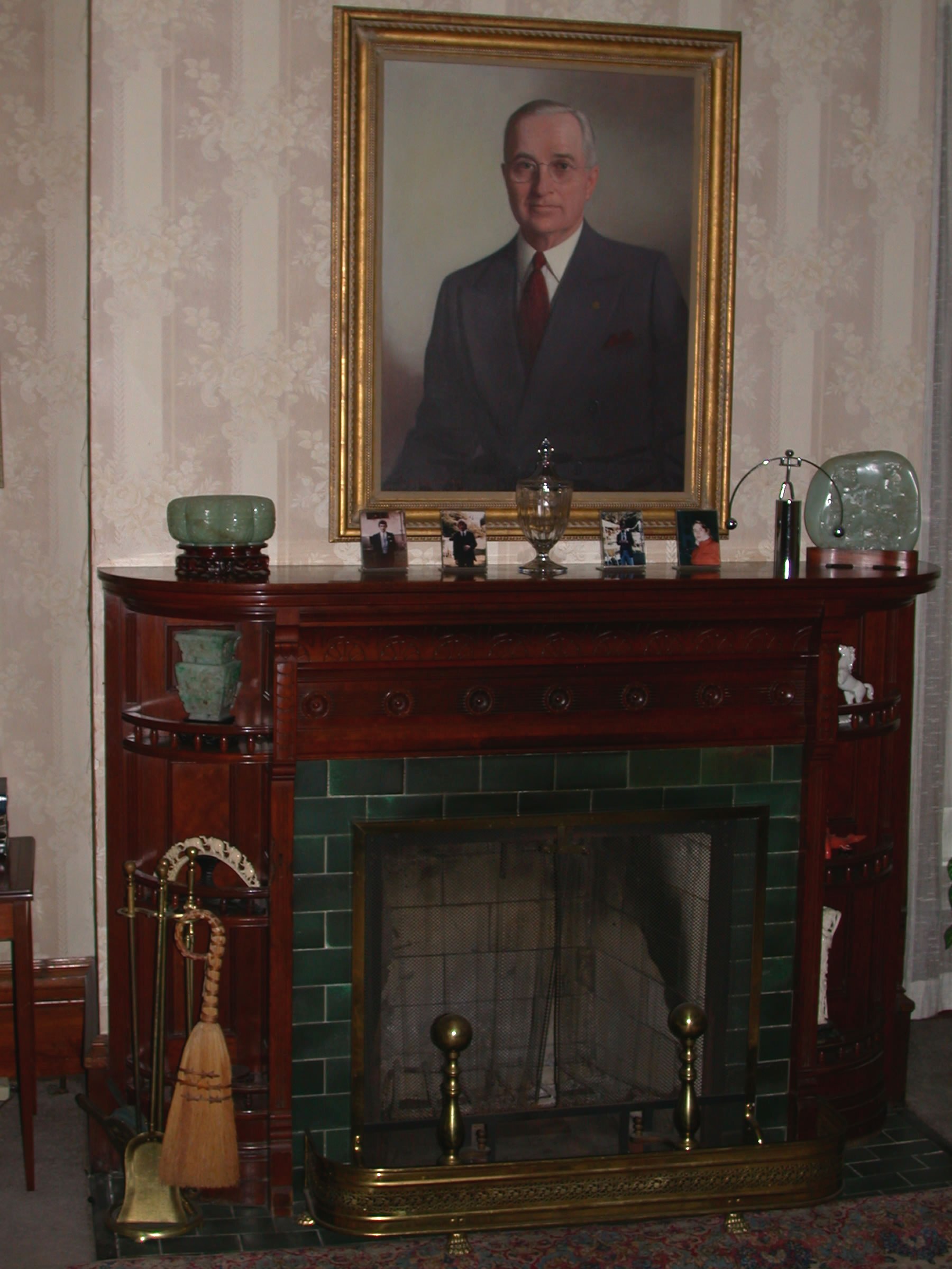 Living Room, fireplace with jade pieces and photographs. A large painting of Harry Truman, in coat and tie, from 1945.