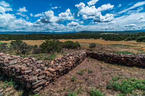 Stacked rocks form a wall under a blue sky