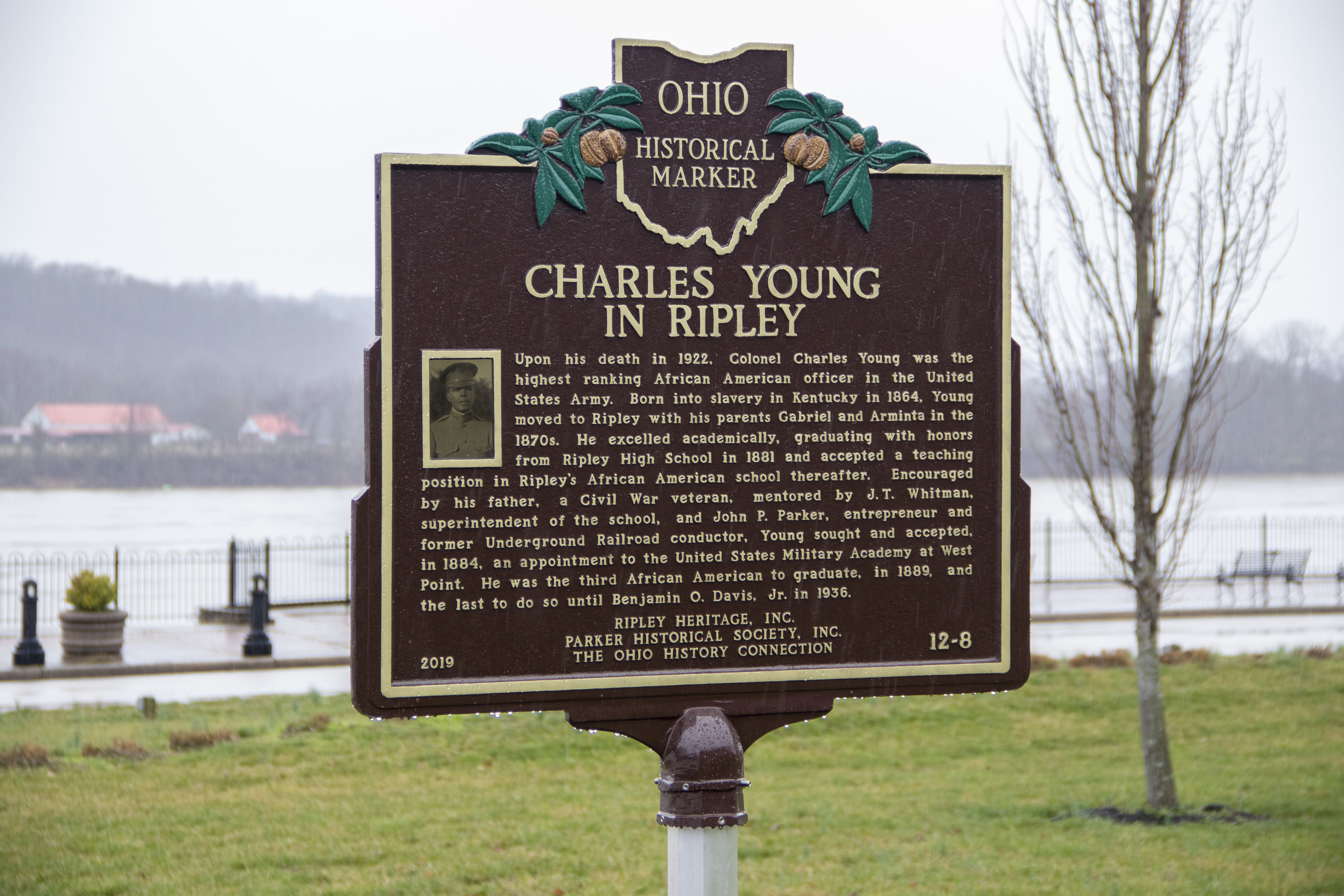 A brown bronze plaque with gold letters in text reading Ohio Historical Marker, Charles Young in Ripley.