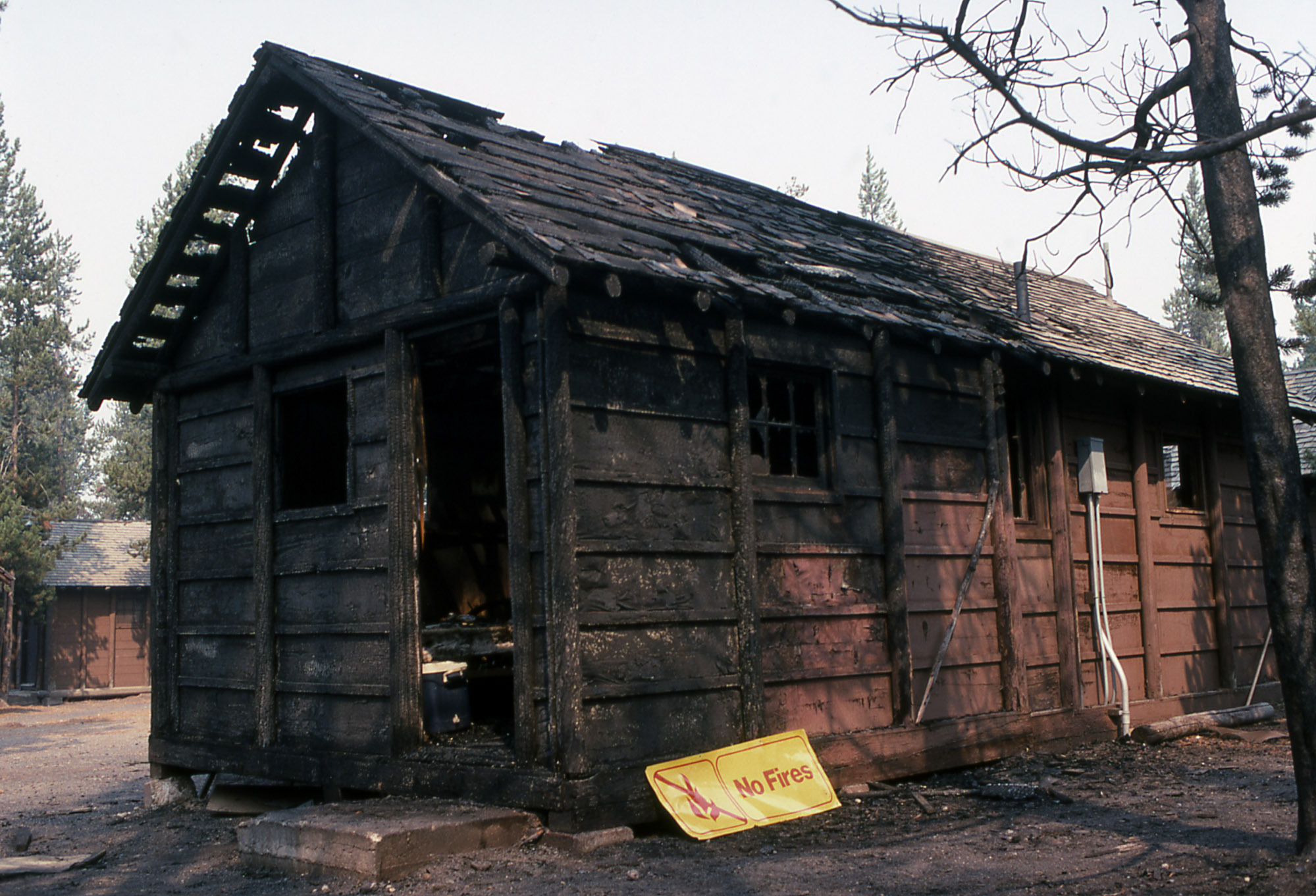 A wooden cabin has been burned on one end.