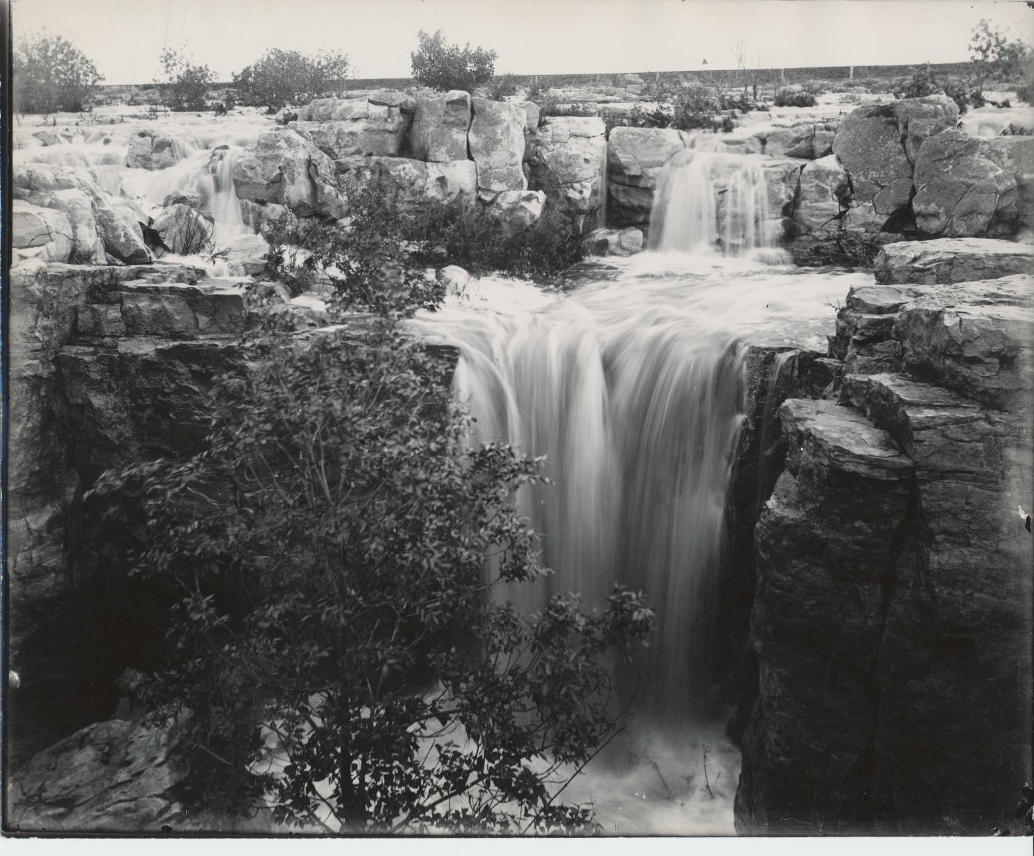 Black and white photo of waterfall with little smaller falls above it