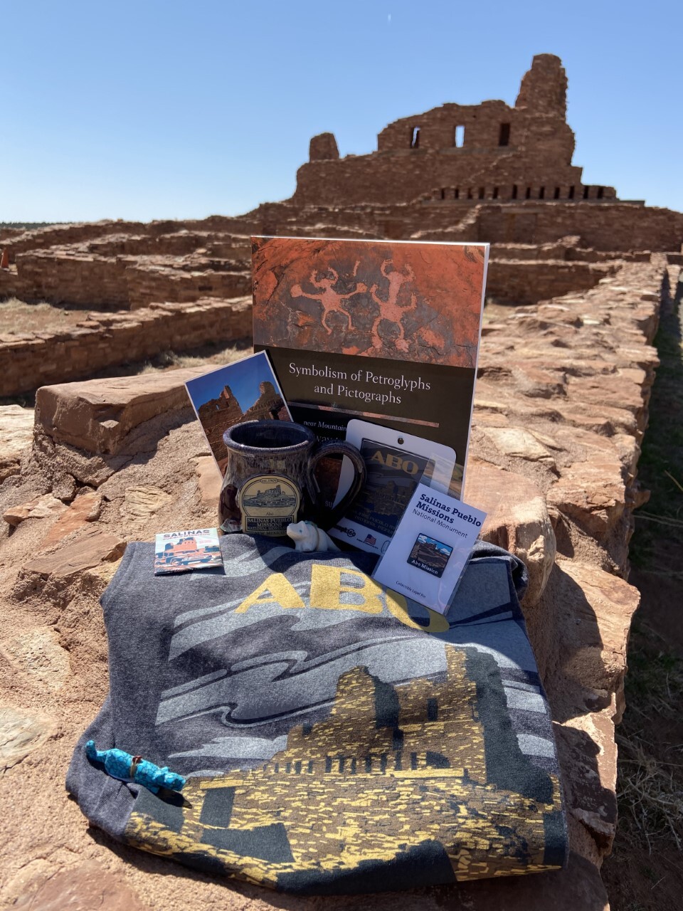 Souvenirs displayed in front of the ruins of a red sandstone church.