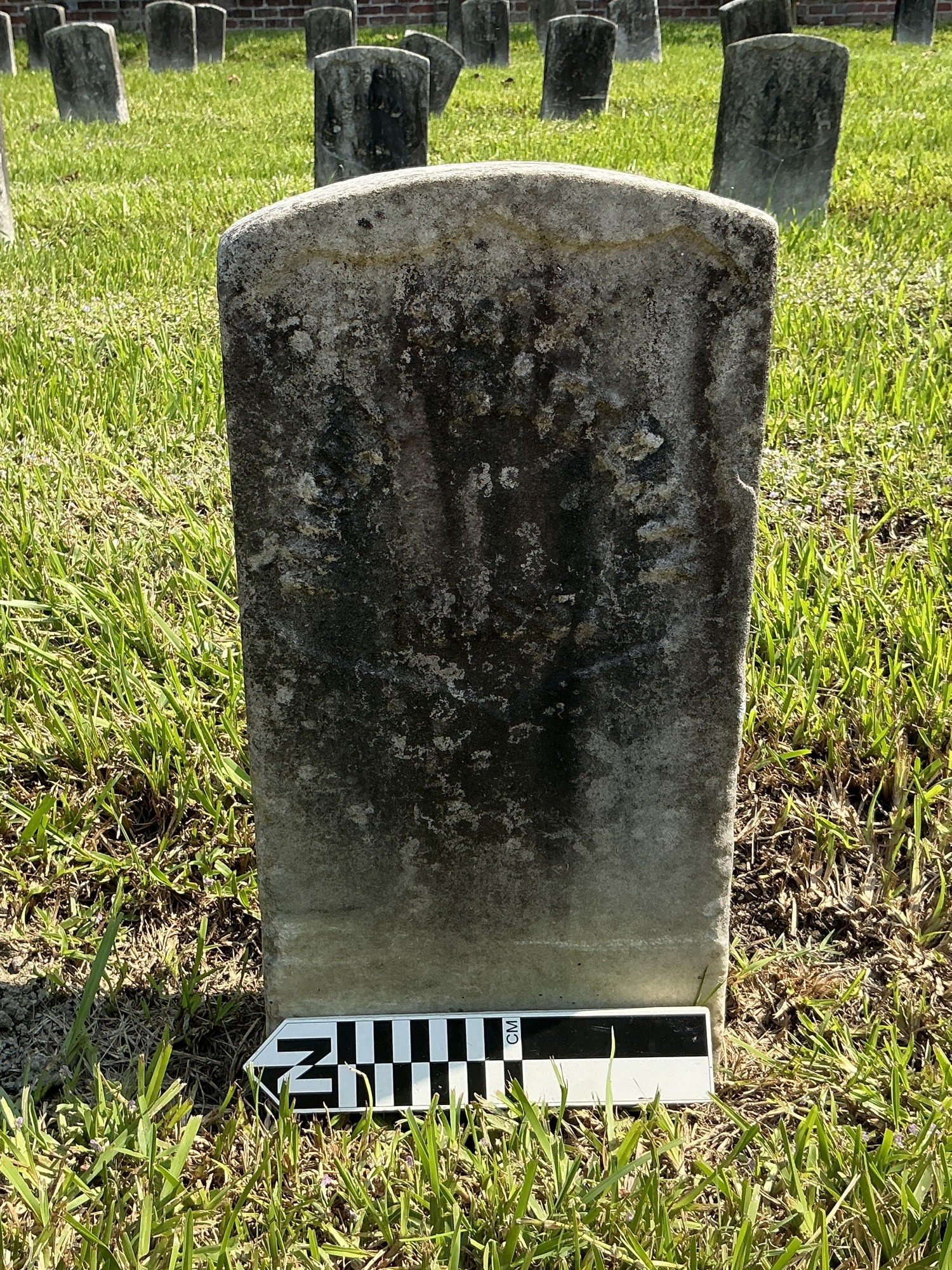 Extra image of historic upright marble headstone with recessed shield face.