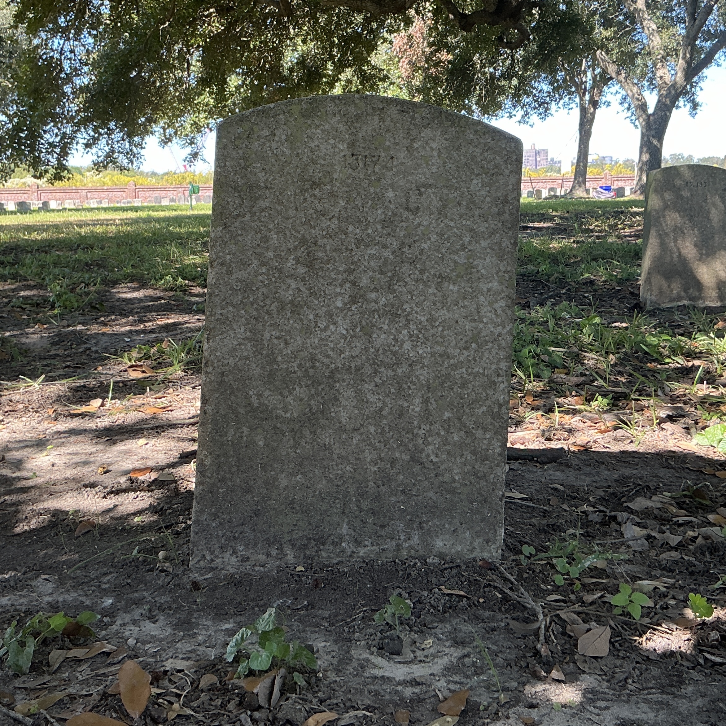 Back of upright marble headstone with flat face.