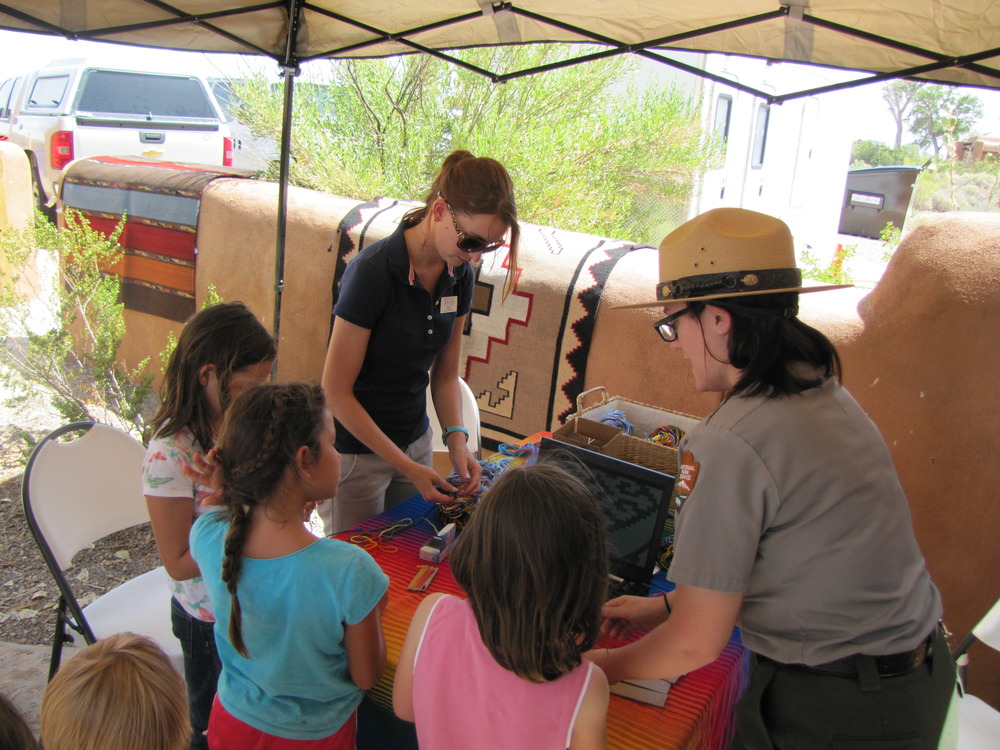 A ranger staffs a craft table for kids.