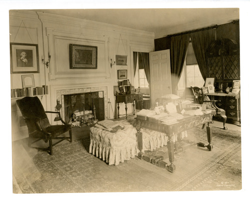 Black and white photograph of 19th century study featuring Renaissance revival library table, Empire revival couch and desk.