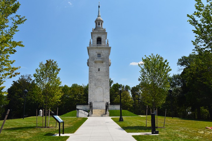 Dorchester Heights Monument, a white granite stepped tower surrounded by trees and grass.