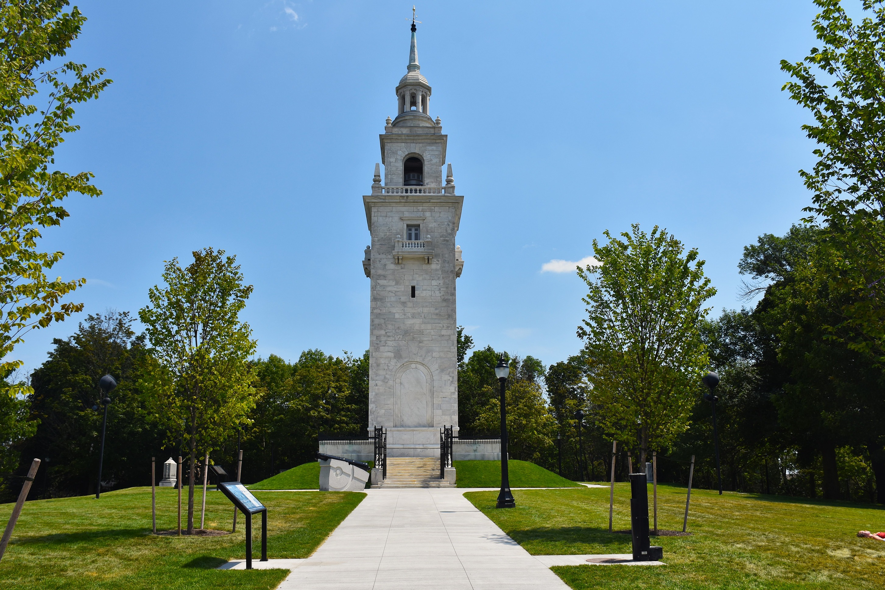 Dorchester Heights Monument, a white granite stepped tower surrounded by trees and grass.