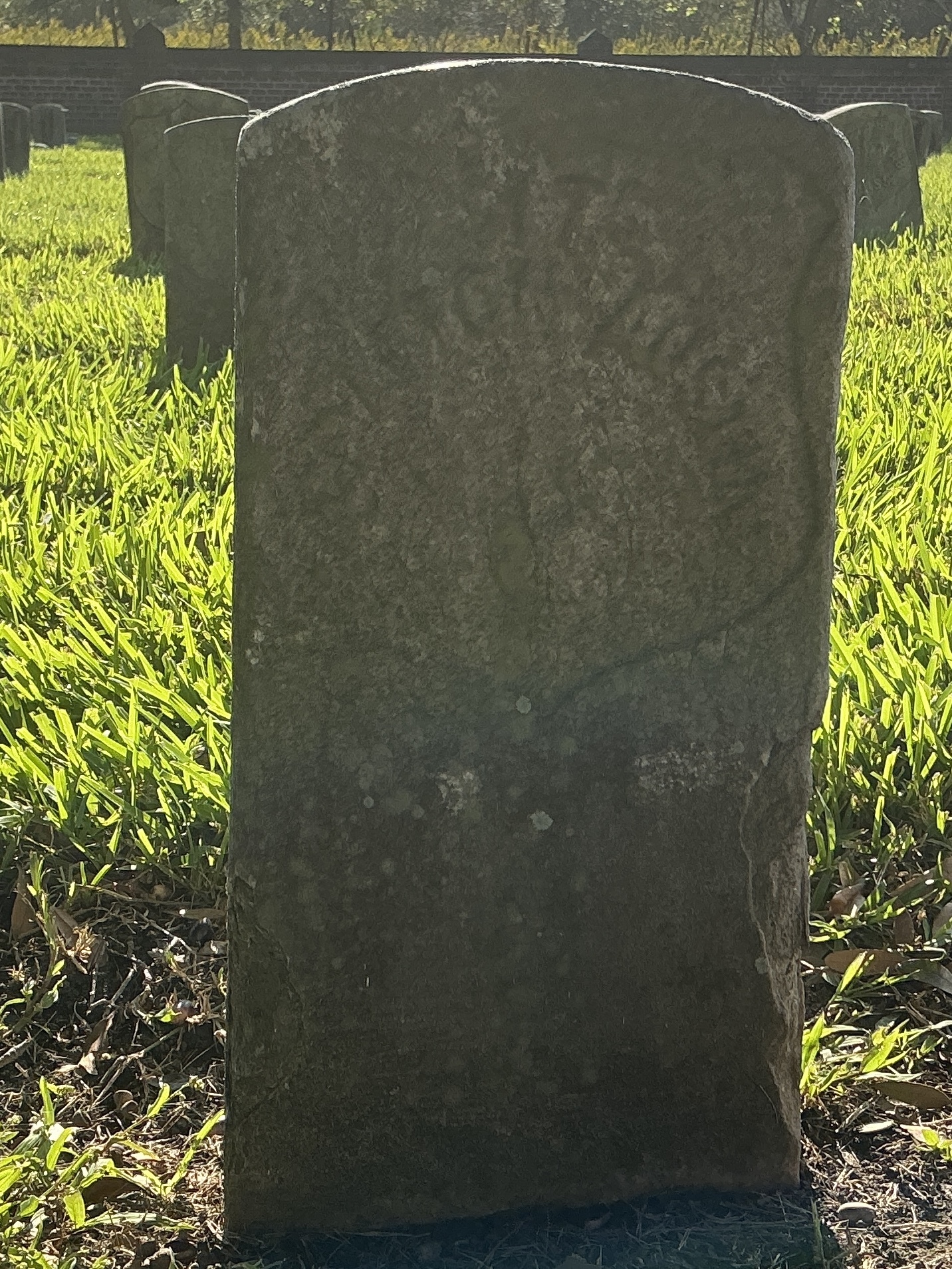 Front of historic upright marble headstone with recessed shield face.