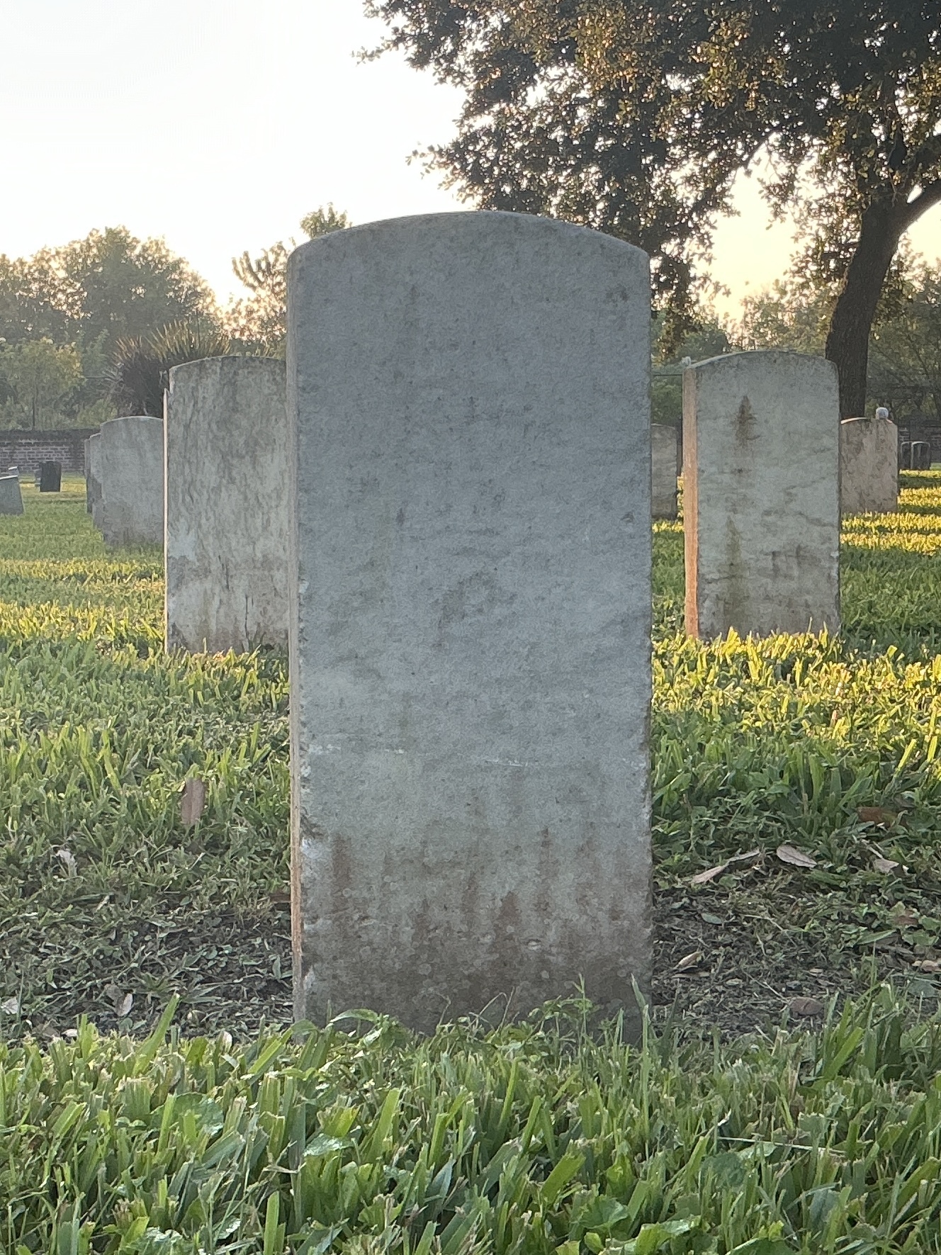 Back of historic upright marble headstone with recessed shield face.