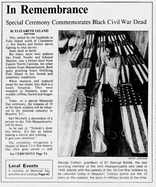 An article called "In Remembrance: Special ceremony Commemorates Black Civil War Dead." A picture to the right shows a man standing in the middle of 19 caskets covered in American flags. The caption reads: "George Coblyn, grandson of Eli George Biddle, the last surviving member of the 54th Massachusetts who died in 1940, stands with the caskets of 19 Civil War soldiers to be reburied today in Beaufort. Coblyn points out the 13 stars on the caskets, the style of military burials at the time."