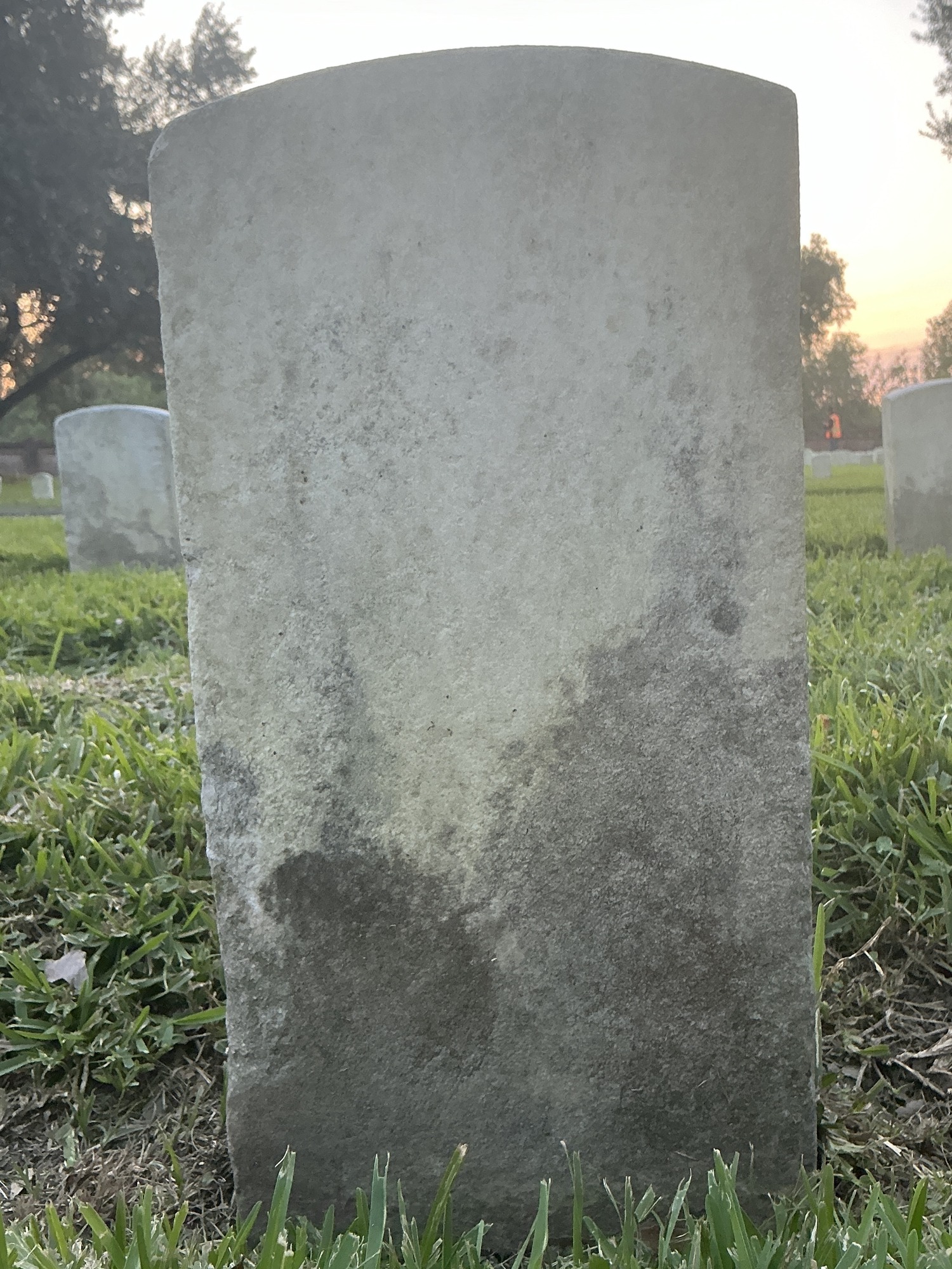 Back of historic upright marble headstone with recessed shield face.