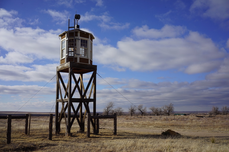 A guard tower rises above the surrounding prairie.