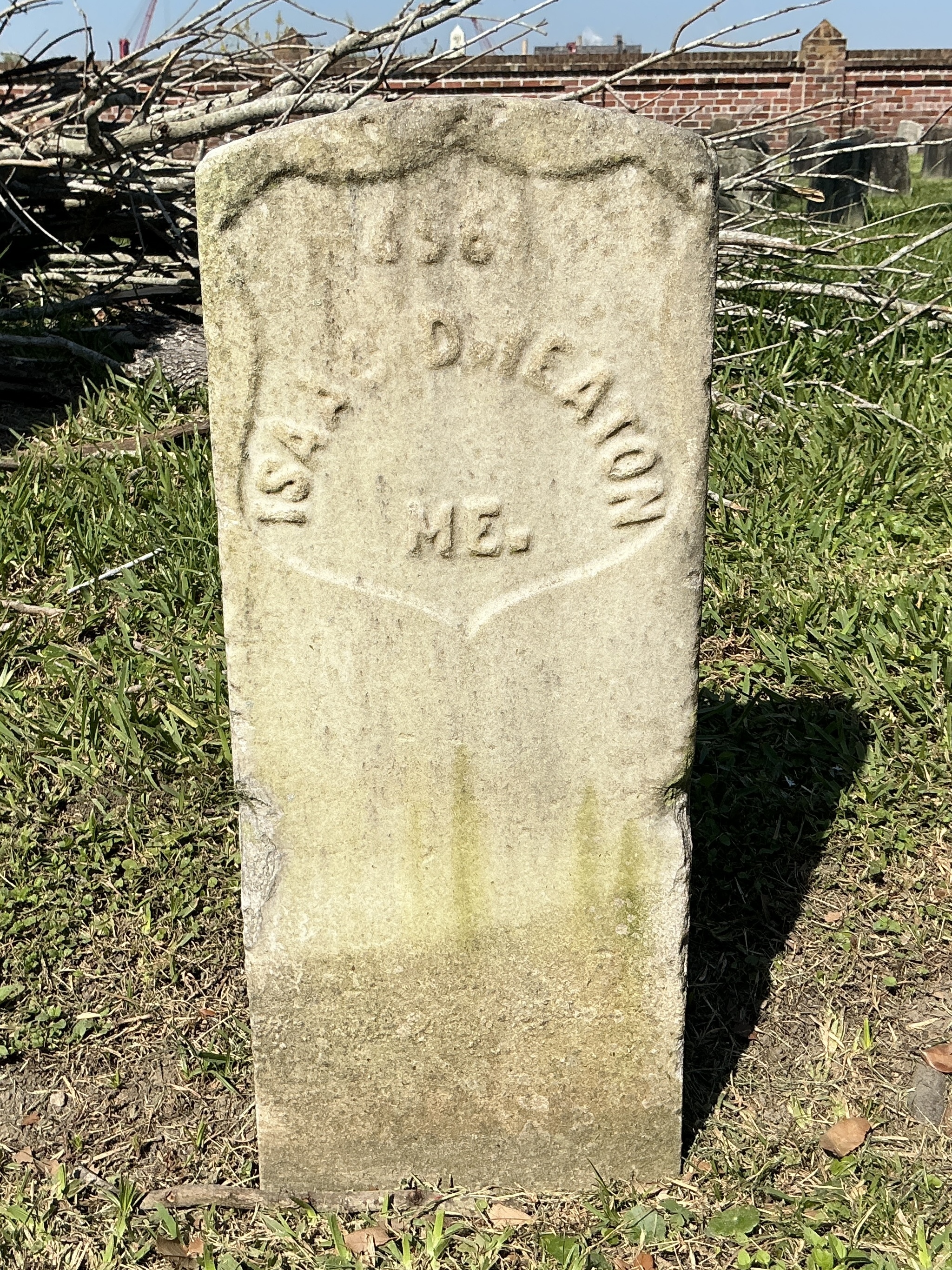 Front of historic upright marble headstone with recessed shield face.