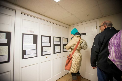 A woman reads an exhibit of visitor's memories of November 22, 1963