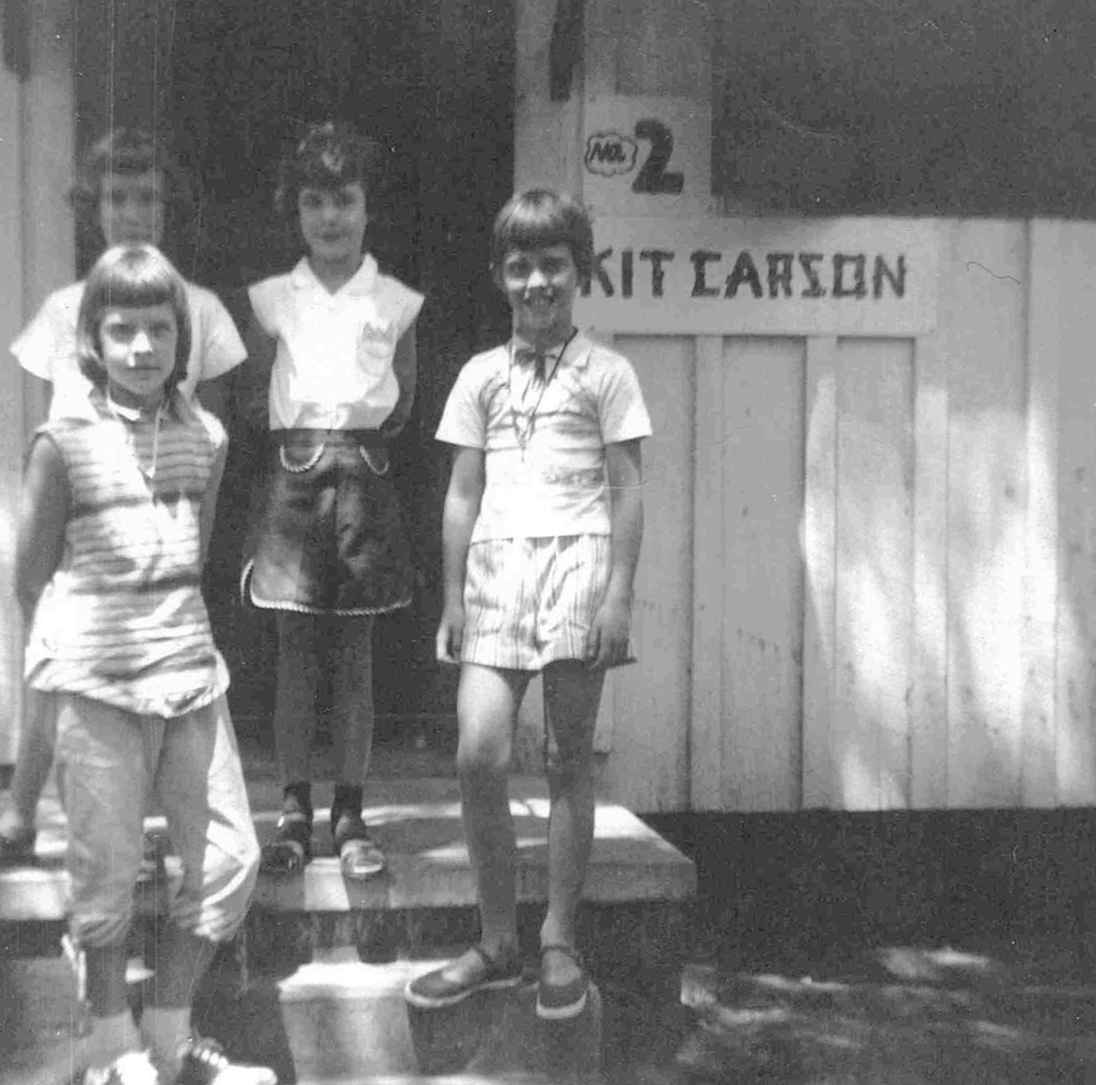 black and white photo of kids in the doorway to a cabin