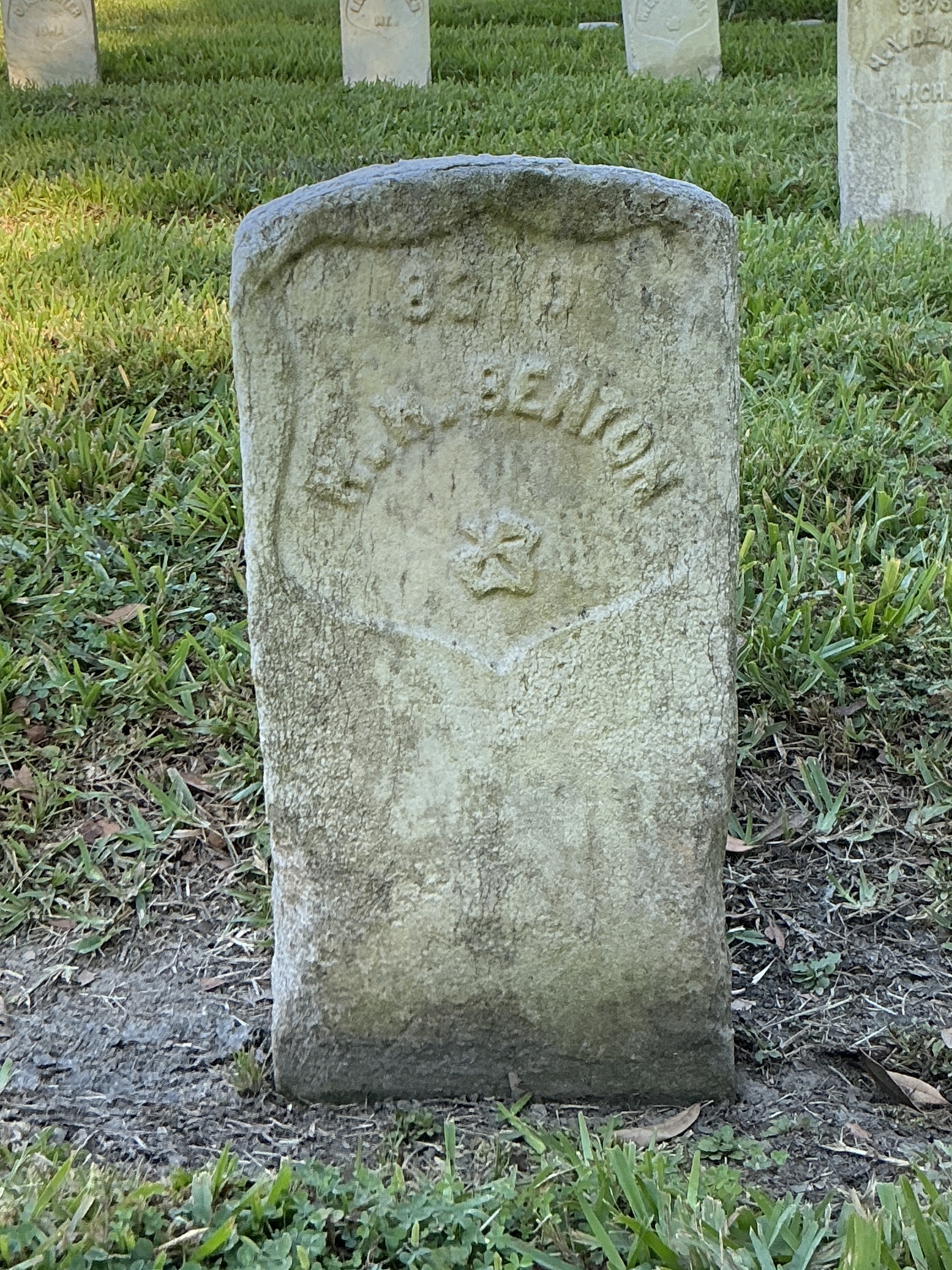 Front of historic upright marble headstone with recessed shield face.