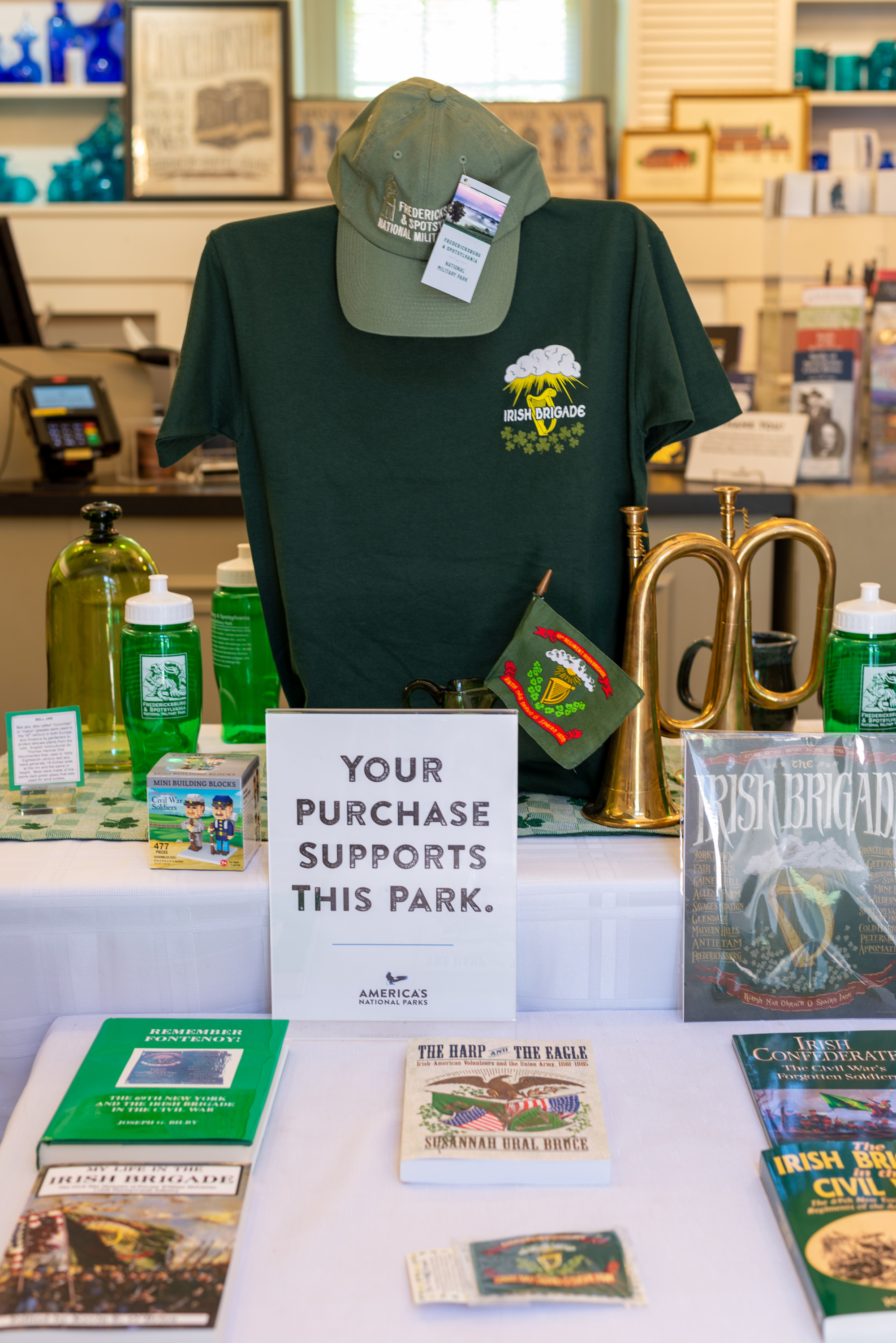 A gift shop display with books and t-shirt, all green and about the Irish Brigade.
