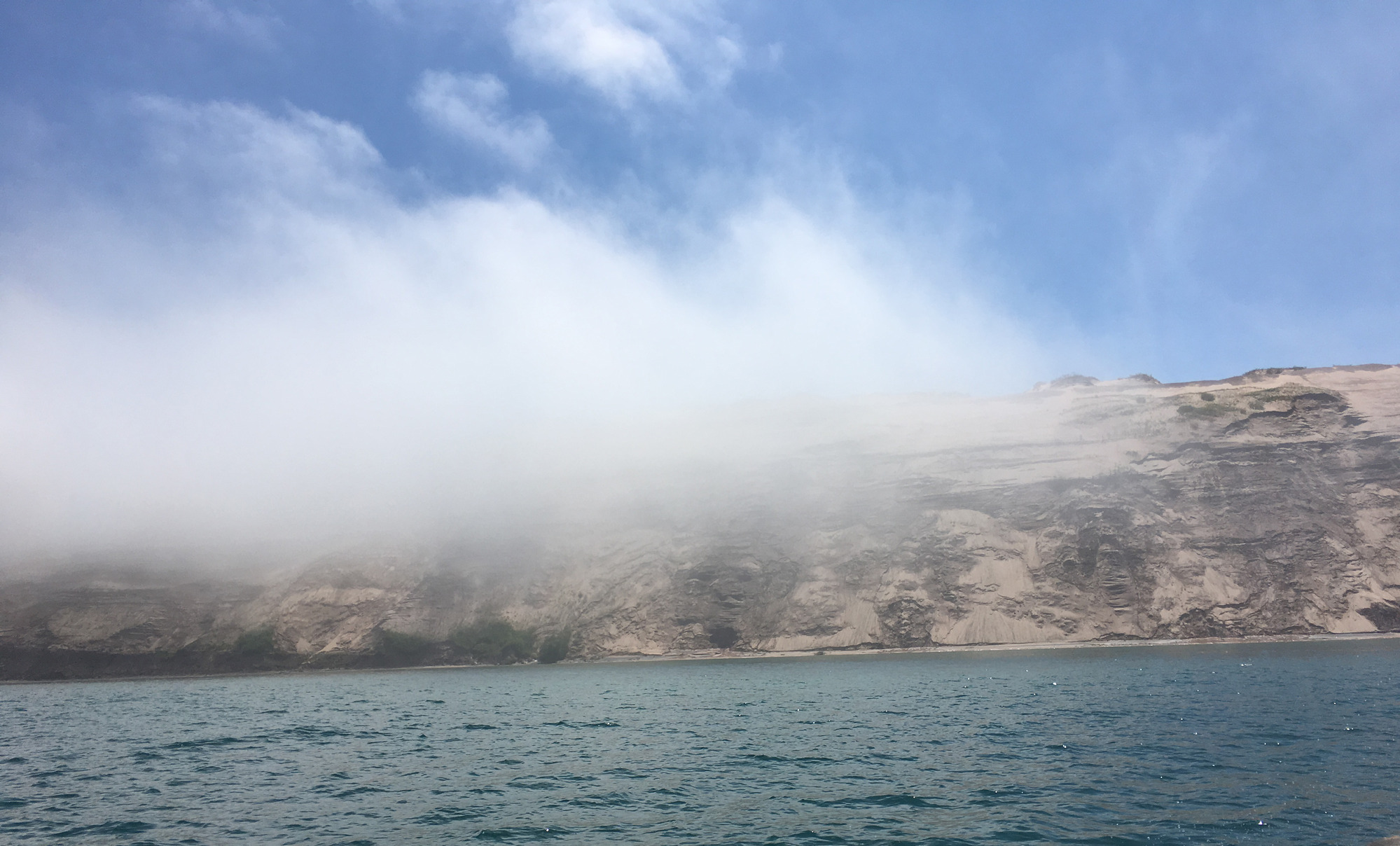 Fog is forming over the dunes like low clouds.