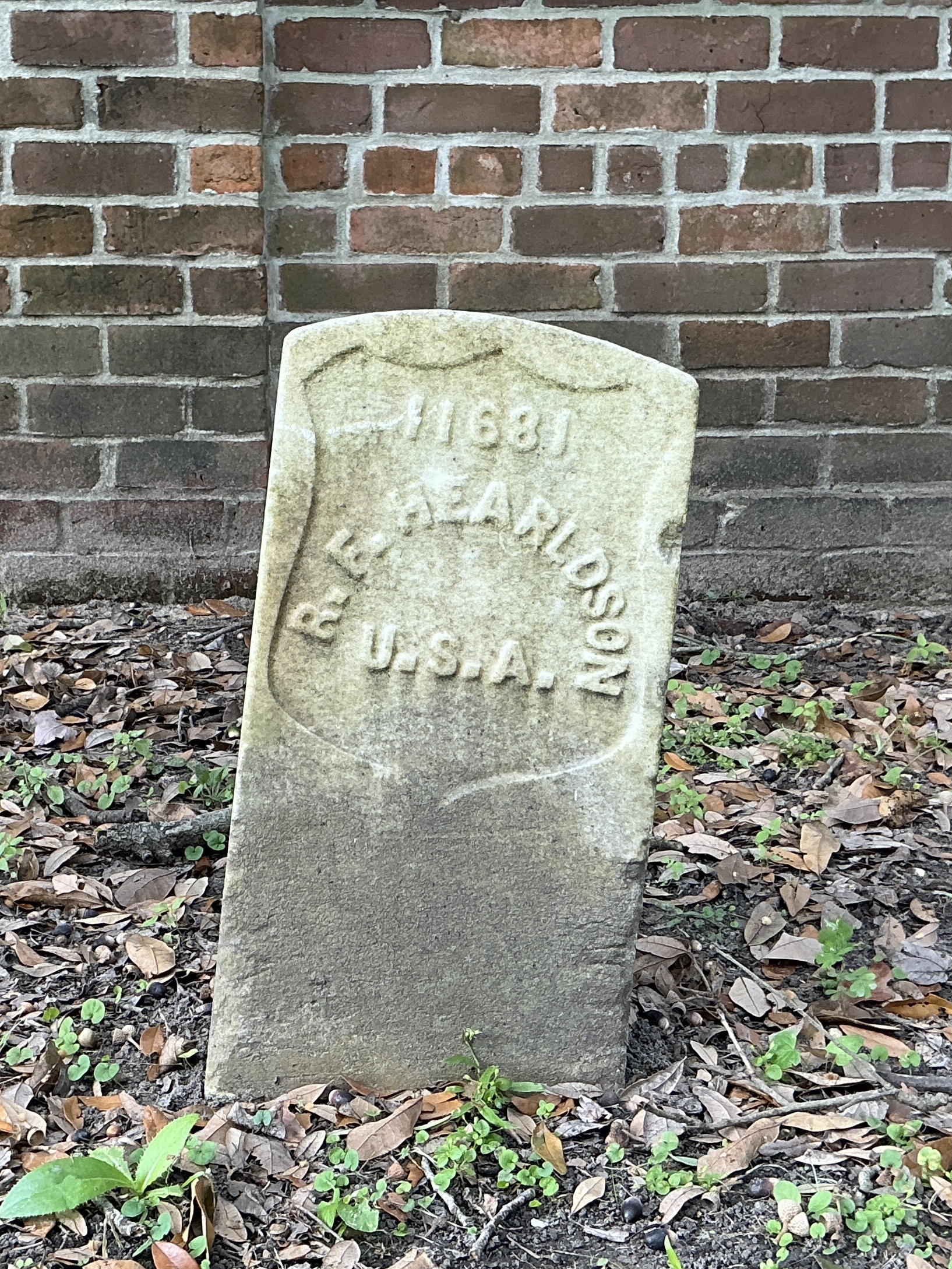 Front of historic upright marble headstone with recessed shield face.
