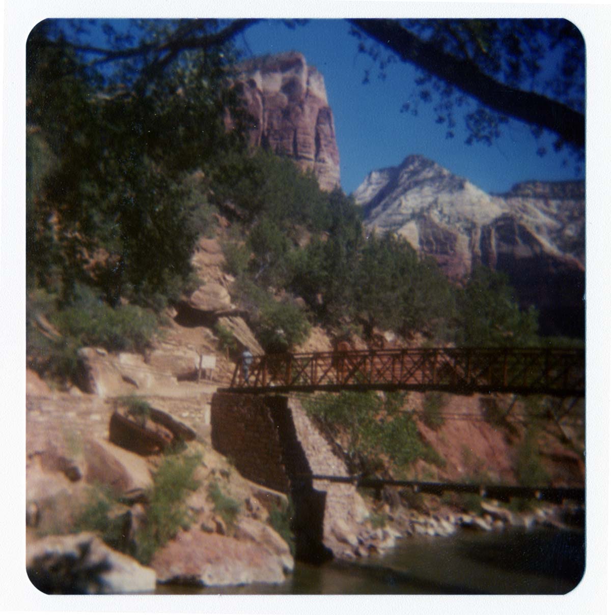 Man crossing the new Grotto footbridge after its placement on stone abutments.