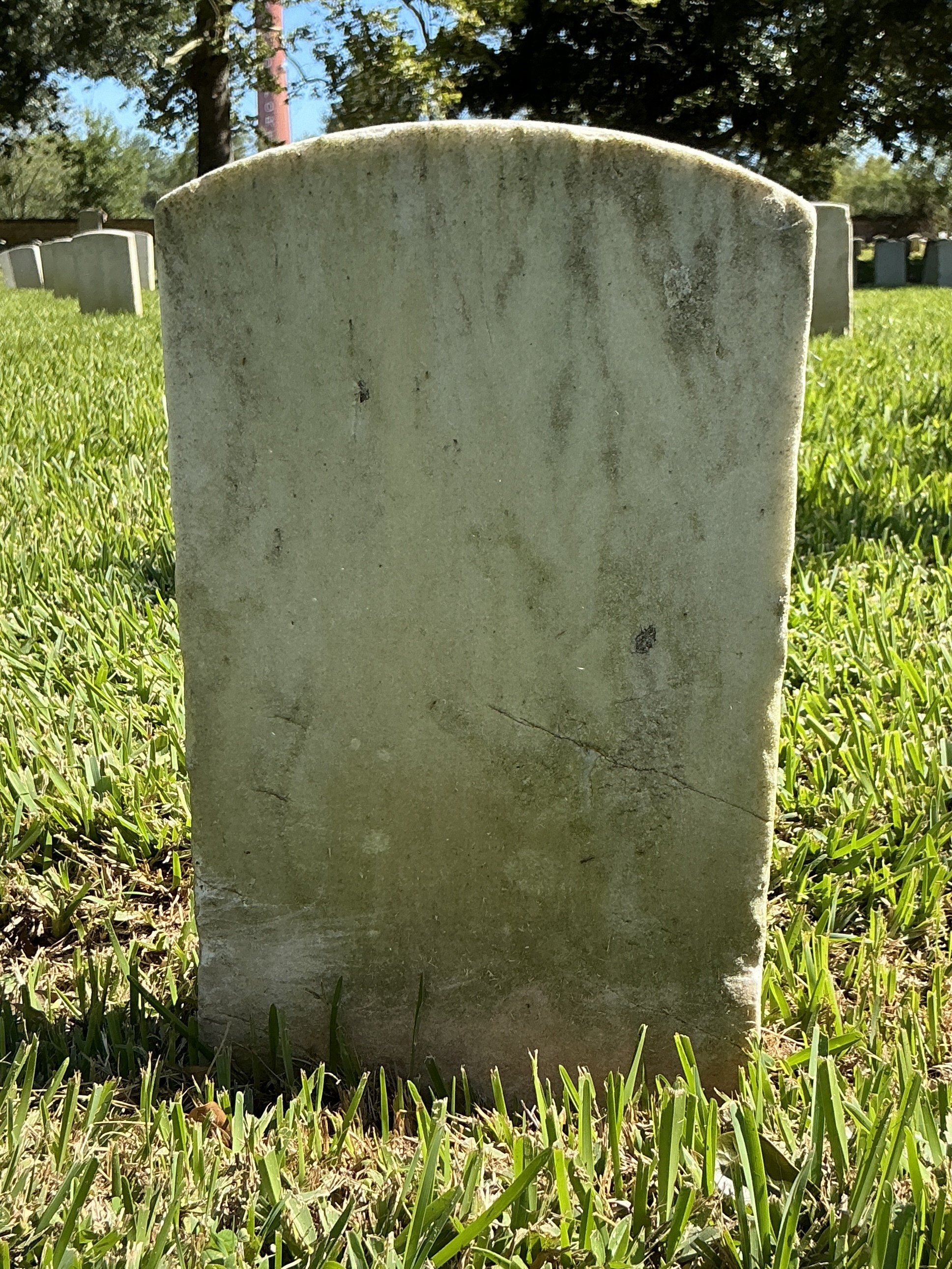 Back of historic upright marble headstone with recessed shield face.