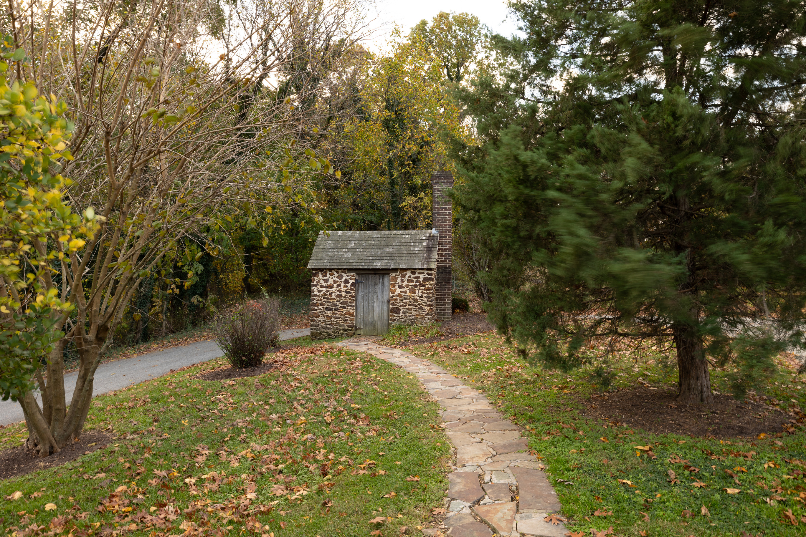 A stone pathway leading to a small house