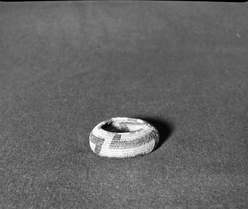 Marie Rozier Collection, Catalog No. 152. Object: Pomo basket. Dimensions: 3 1/2" diameter x 1 1/4" height. Materials: sedge root, willow rod, redbud, bullrush. Technology: interlocking stitch, bullrush used on top coil only, remnants of quail topknots and cotton thread (which probably was a clam bead handle). Collection History: Gift from M. Long. Photographed by Michael Dixon, December 1982. Catalogued by Craig Bates and Barbara Beroza. Yosemite Collections, National Park Service.