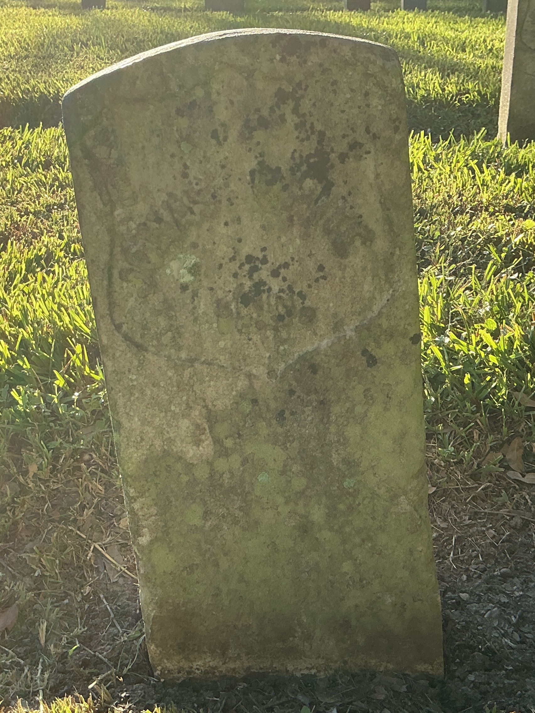 Front of historic upright marble headstone with recessed shield face.