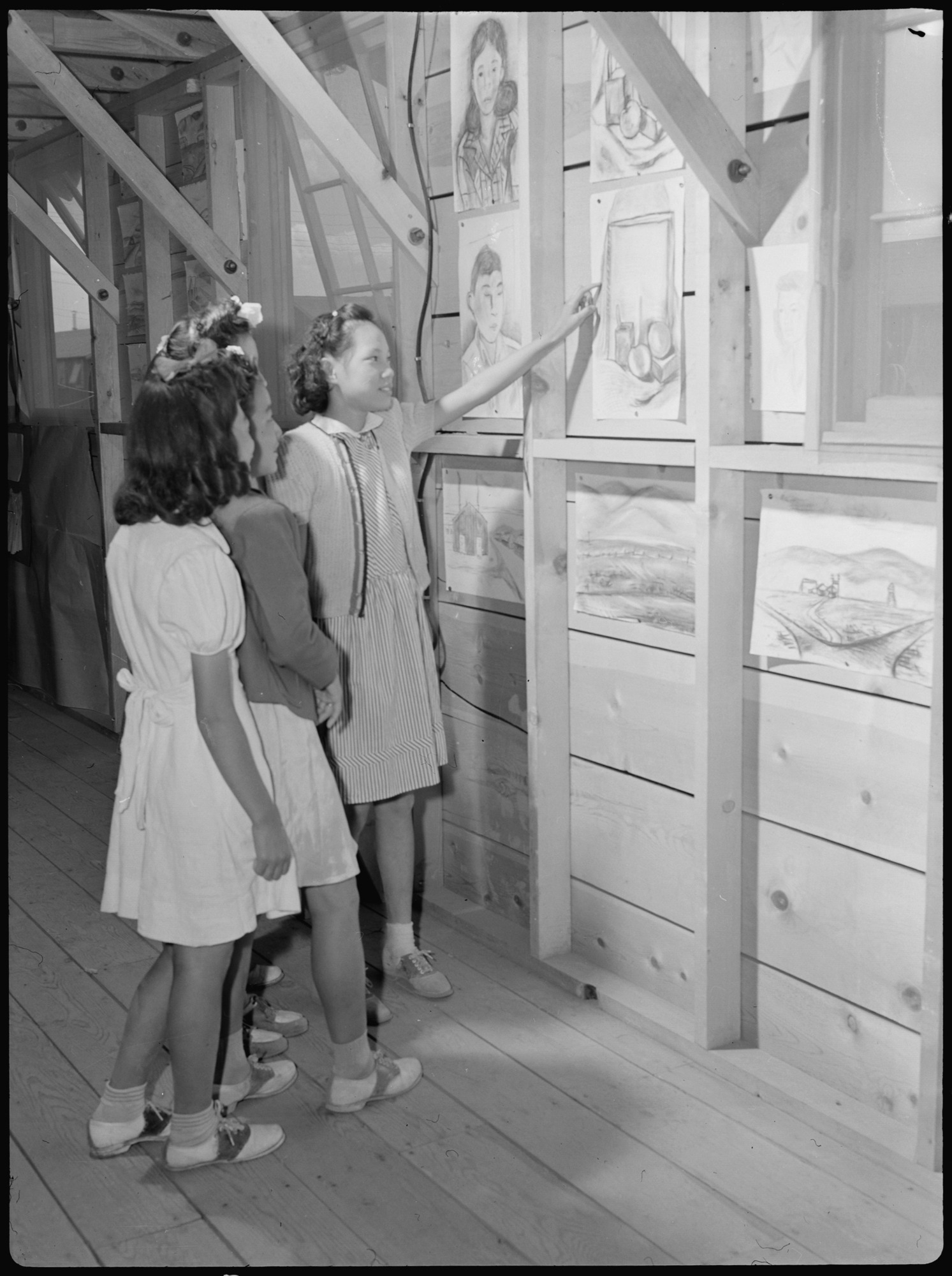 An evacuee school girl proudly shows friends her art work which was on display in the exhibit shows held on labor day