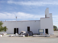 A white building close to a road.