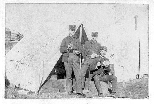 The photo is faded and looks likes it has pencil marks.  Two men standing and one sitting in front of at ten.