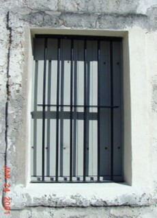 Window, iron bars, and wooden shutters.