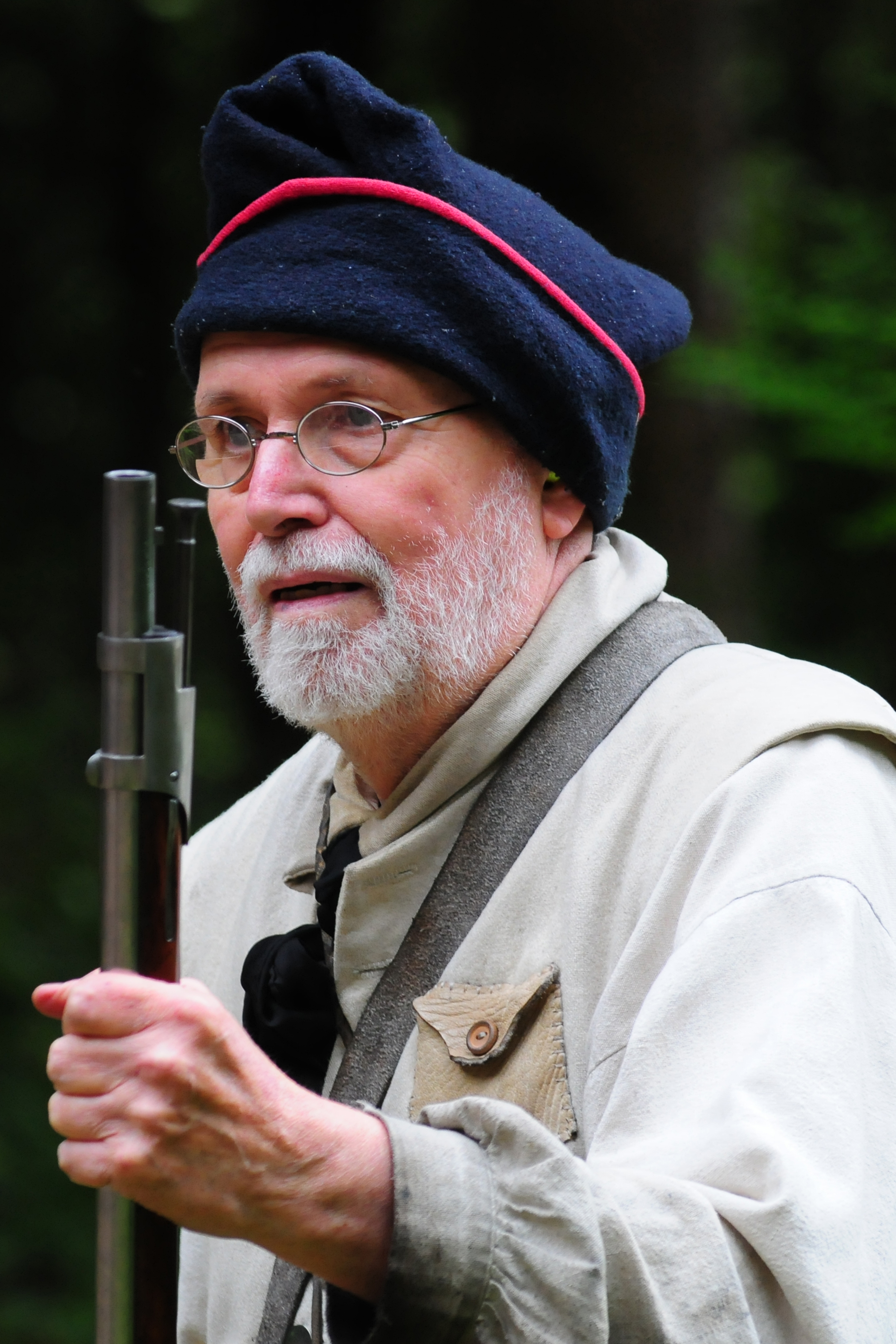 Ranger in 1800s attire holding a flintlock musket.