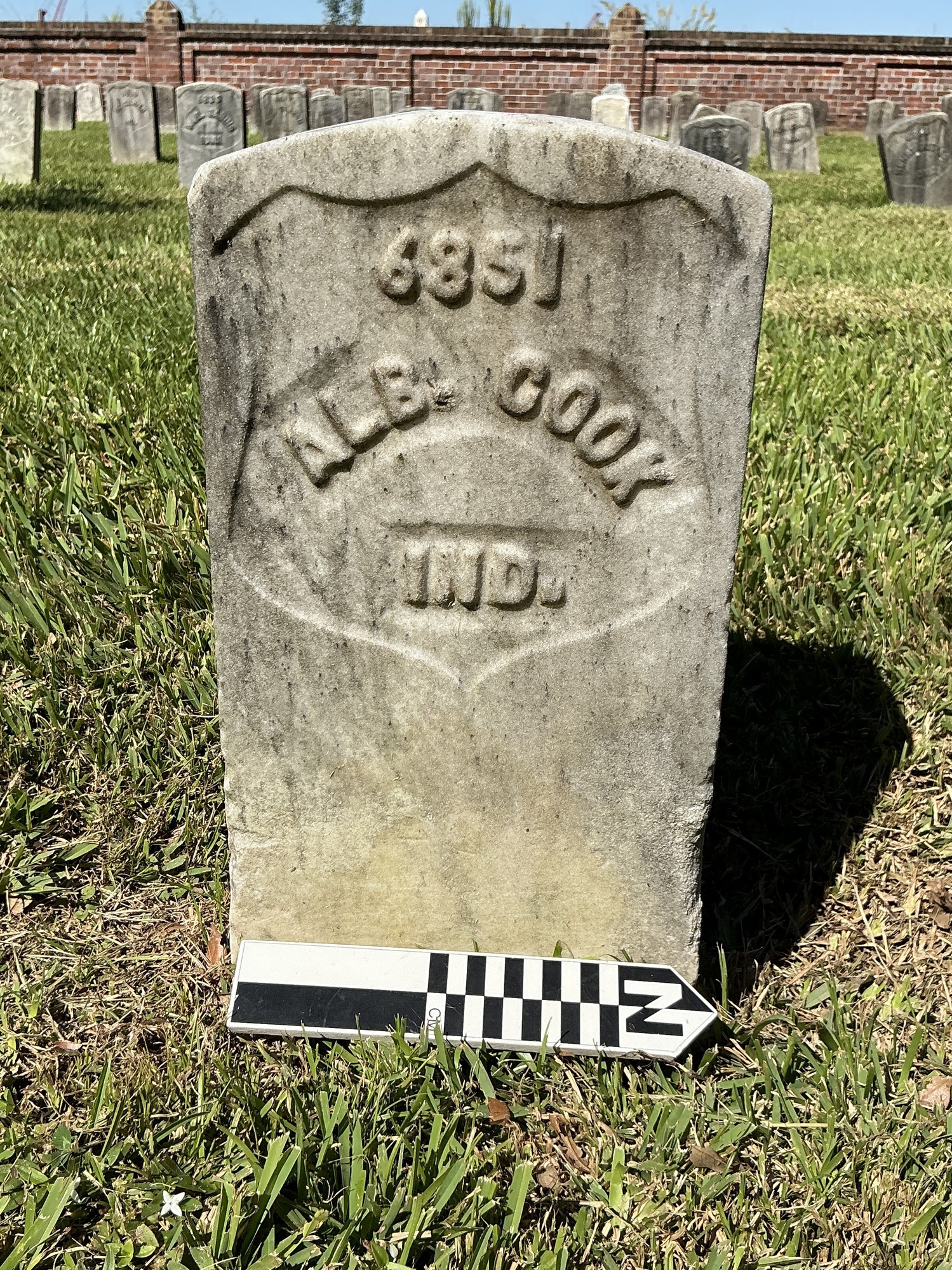 Extra image of historic upright marble headstone with recessed shield with recessed lettering face.