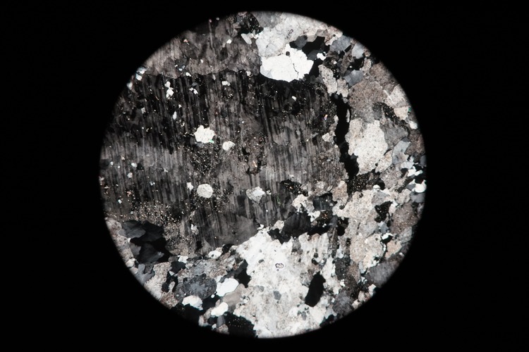 Circular microscopic image of rock structure.