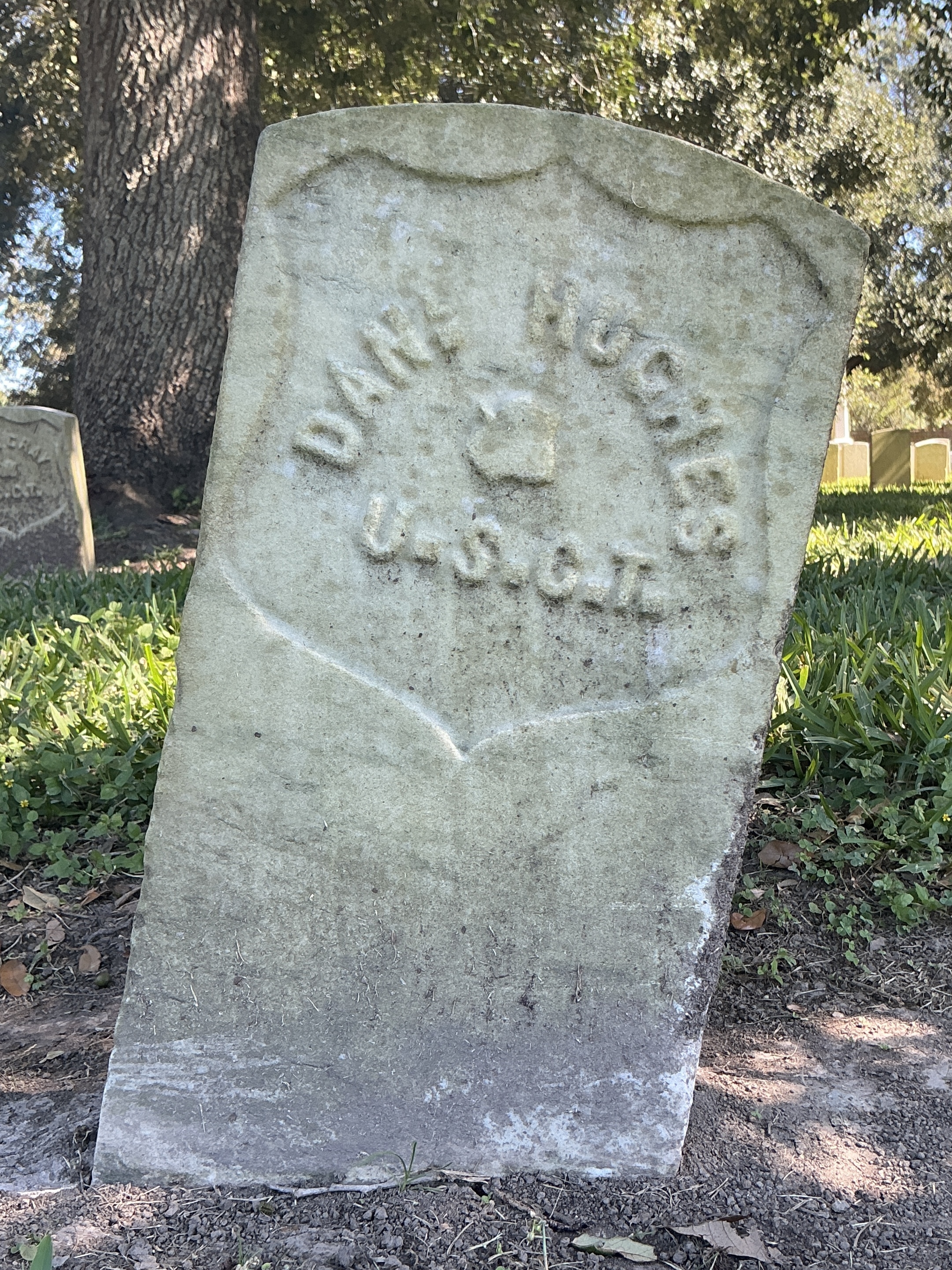 Back of historic upright marble headstone with recessed shield face.