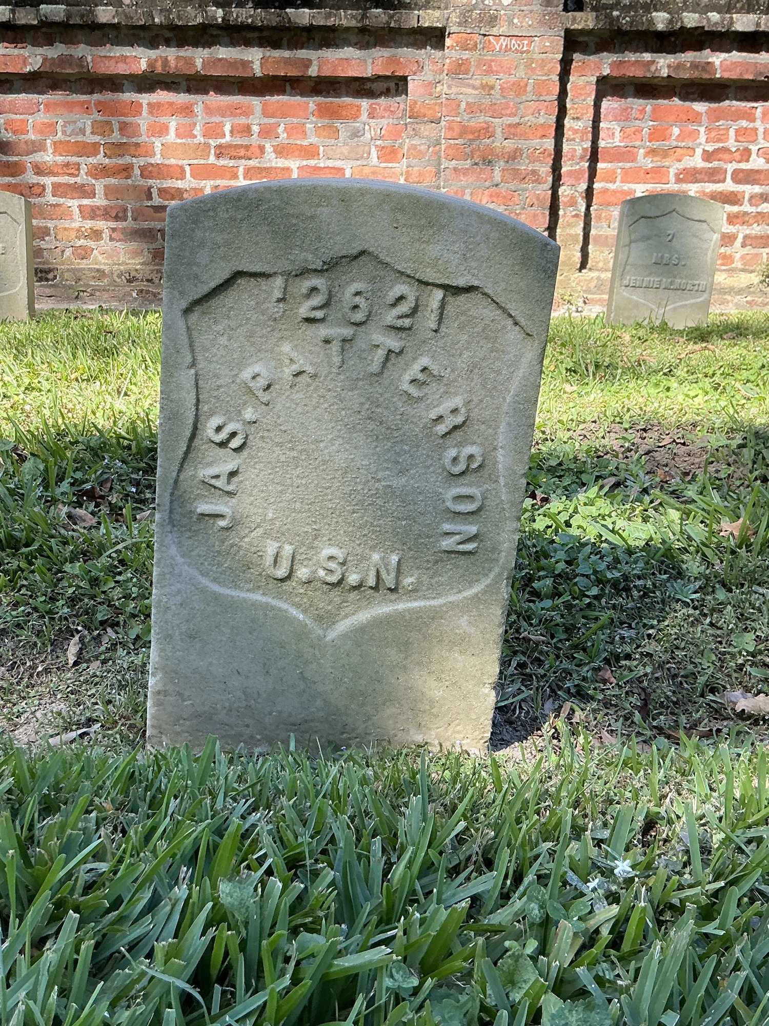 Front of historic upright marble headstone with recessed shield face.