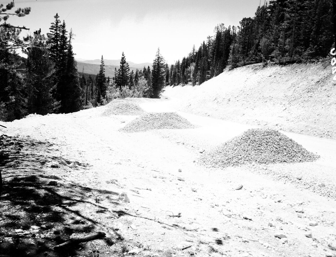 Rock aggregate piles on rim road, prior to graveling road.
