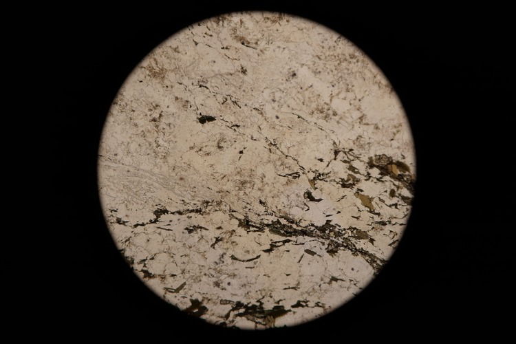 Circular microscopic image of rock structure.