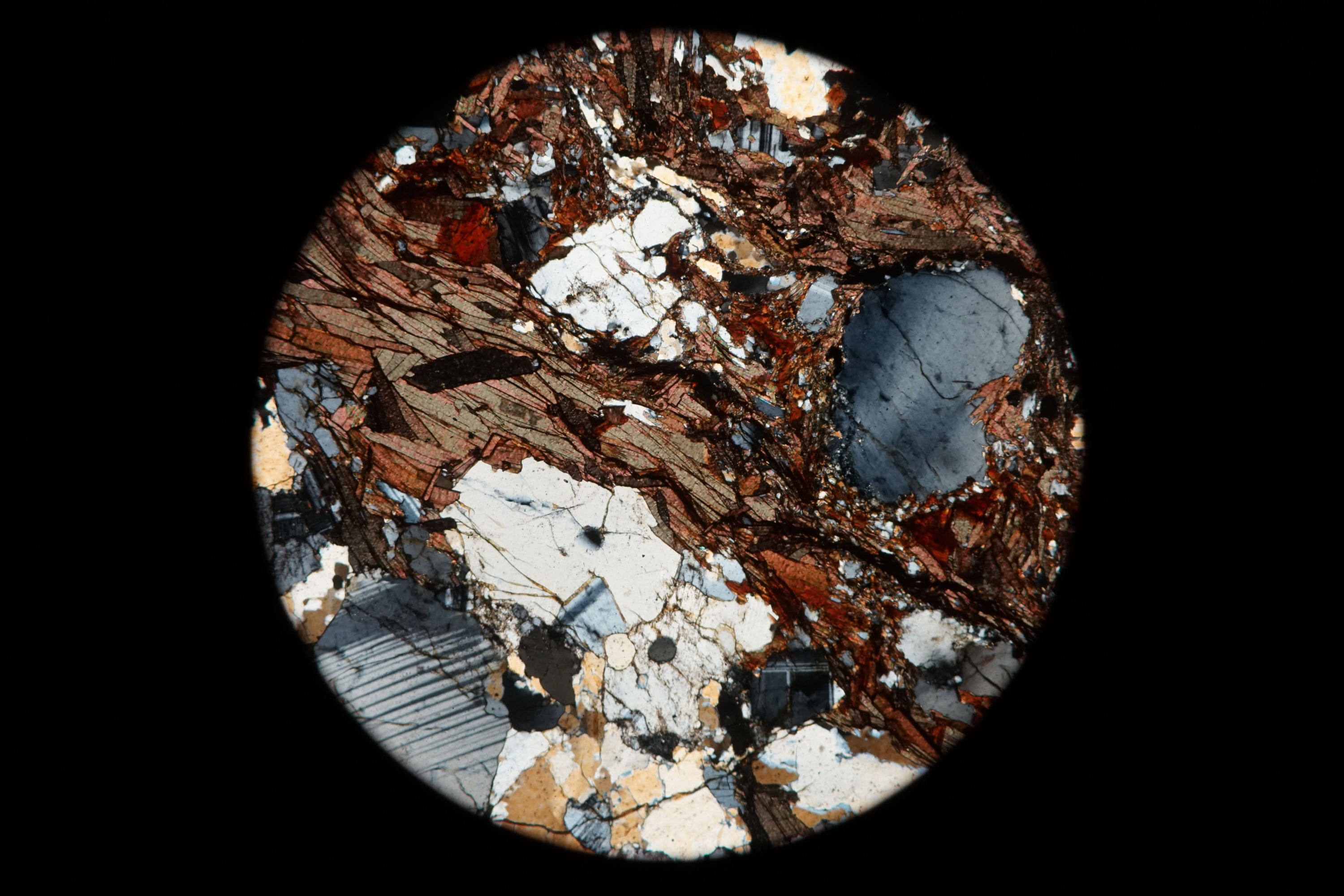 Circular microscopic image of rock structure.
