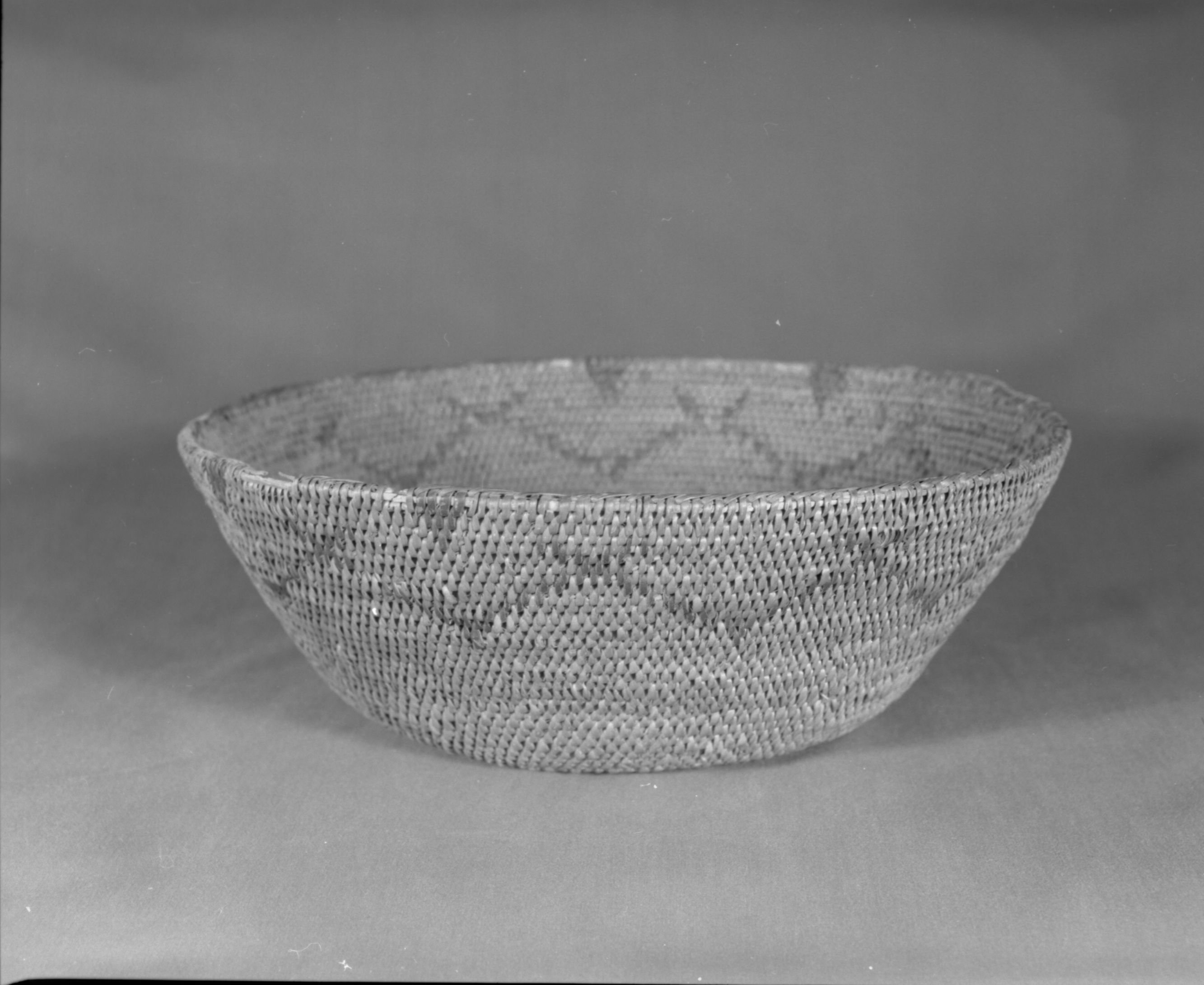 Private Collection. Object: Miwok basket. Dimensions: 12 x 4 1/2". Materials: Bull pine and redbud. Technology: Single rod, fag ends trimmed on work face, moving ends trimmed on interior. Leftward coil direction. Rim overstitched three times. Overstitched clockspring start. Large clockspring ca. 3/4". Collection History: Made by Matilda, a Sonora Miwok, c. 1920. Photographed by Michael Dixon. Catalogued by Craig Bates and Barbara Beroza. Yosemite Collections, National Park Service.