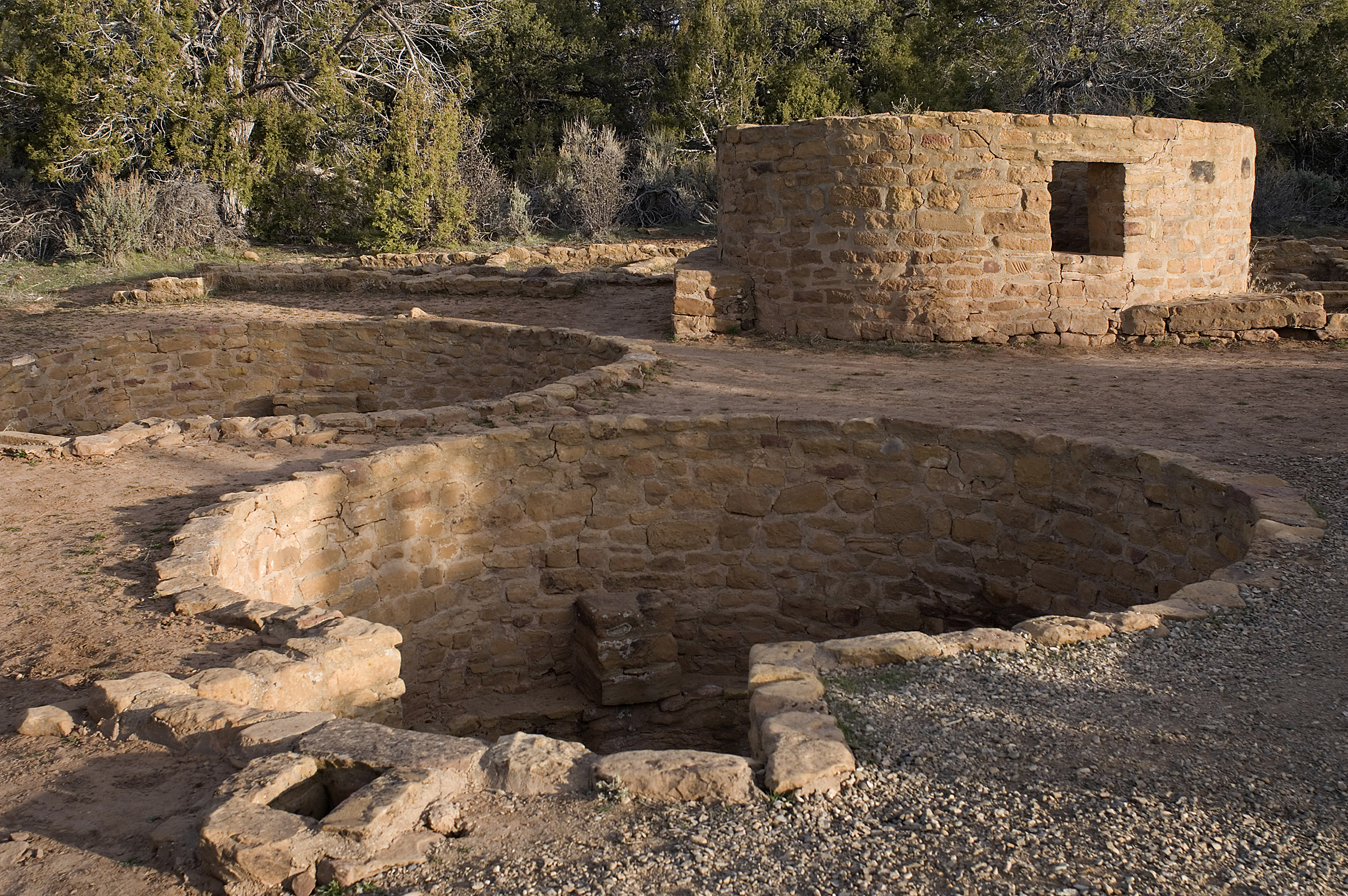 Two round and key-shaped depressions that are lined with stone-masonry walls. Just behind these is a round, one-story, stone-masonry structure.