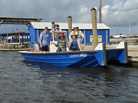 A group of people posing for a picture on a boat that is docked.