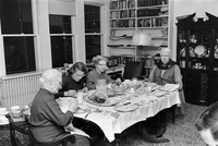 Four adults sitting around table eating breakfast