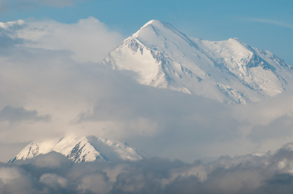 Clouds obscuring a huge snowy mountain