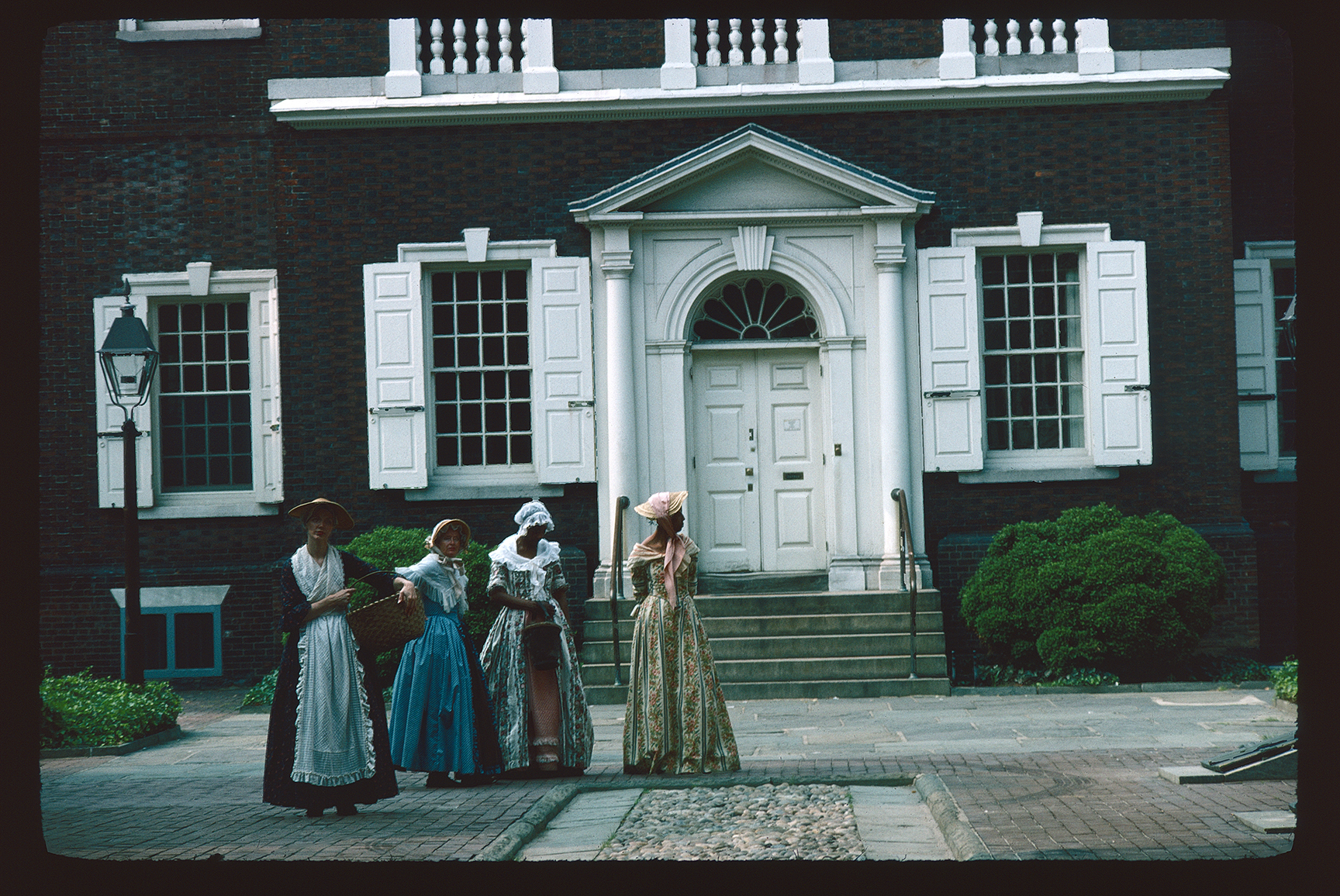 Carpenter's Court. Looking southwest down path toward four female re-enactors standing in front of the front face of Carpenters Hall.