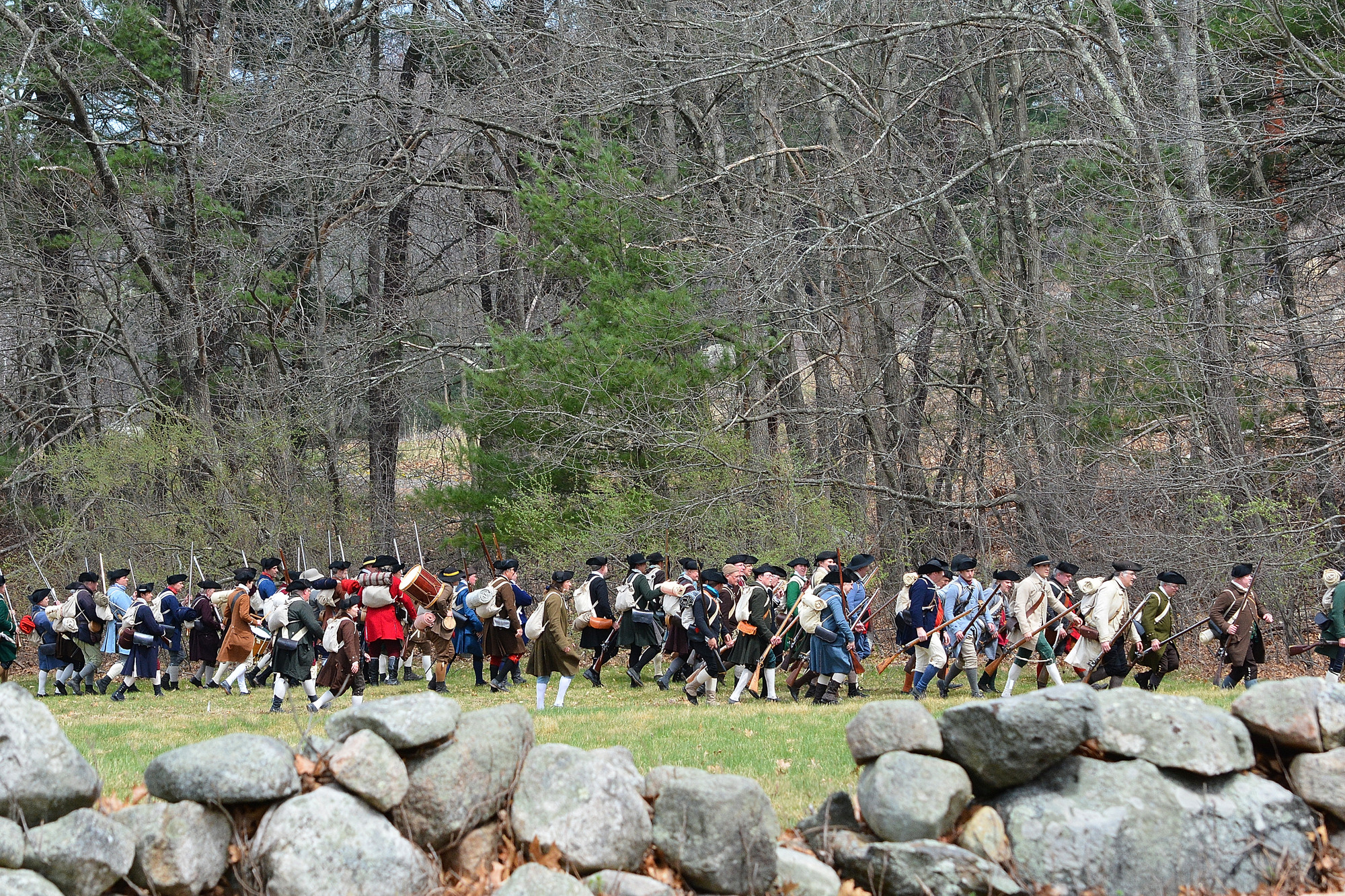 Militia marching along stone wall