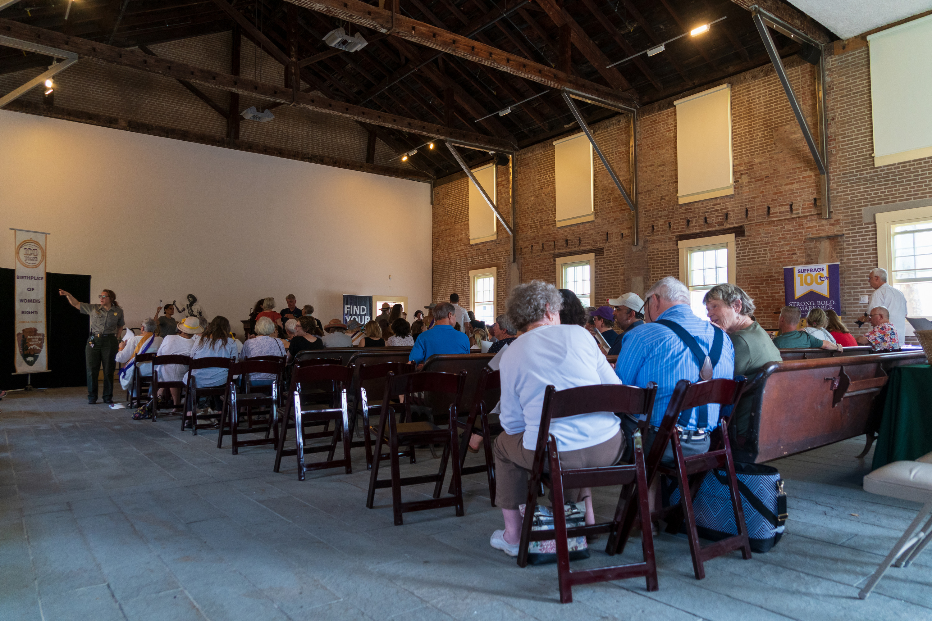 A crowded audience sits in a historical chapel.